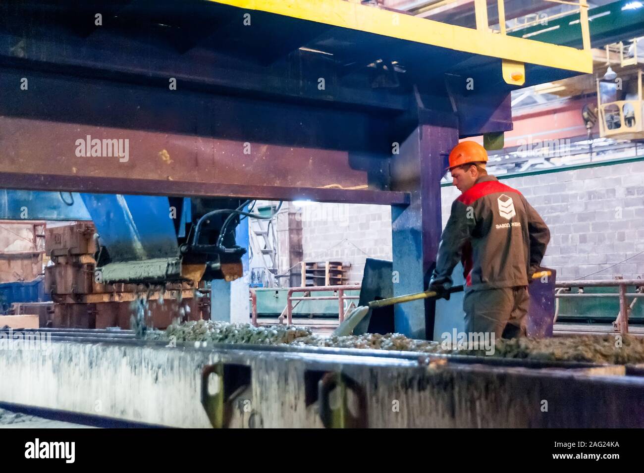 Lavoratore opera la macchina sulla realizzazione di piastre Foto Stock