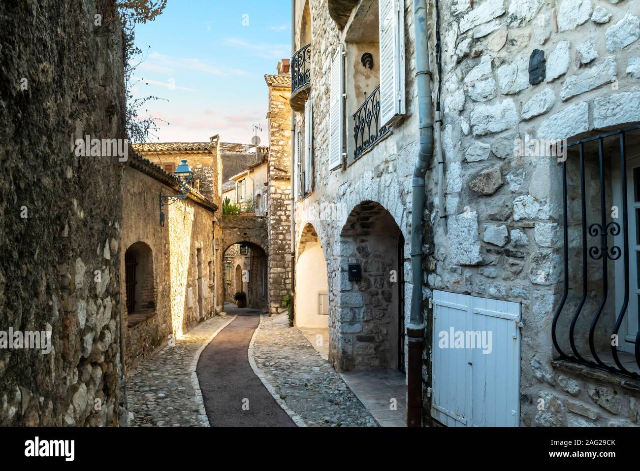 Una stretta di ciottoli, vicolo di pietra attraverso la collina della città medievale di Saint Paul de Vence, Francia al tramonto. Foto Stock