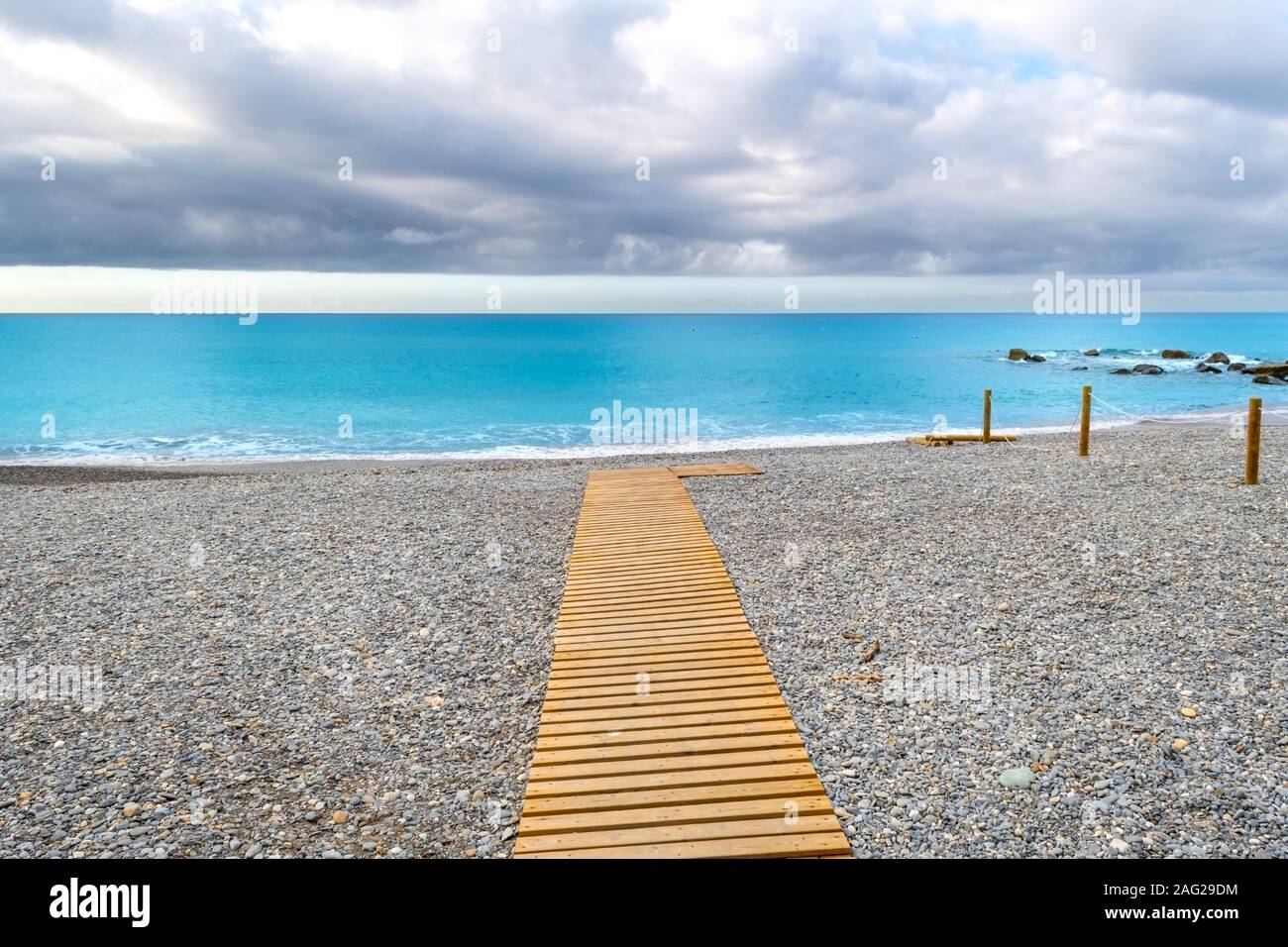 Una spiaggia sentiero verso il mare su una mattina nuvoloso sulla Riviera Italiana a Ventimiglia, Italia Foto Stock