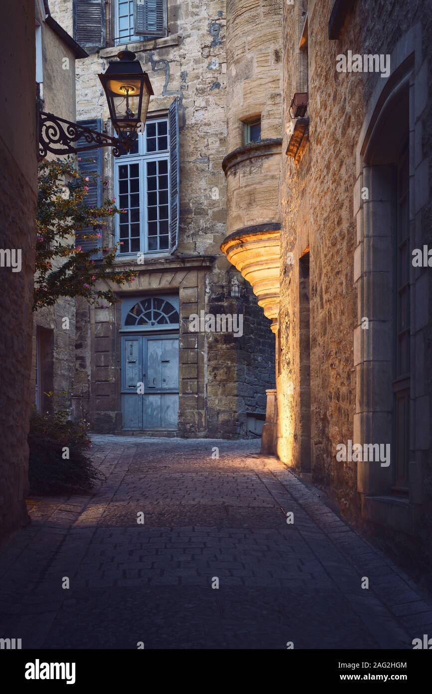 Piccolo vuoto old street con case in pietra e un lampione in una storica città medievale di Sarlat nel sud della Francia. Artistica Città vecchia scenografia all'alba Foto Stock