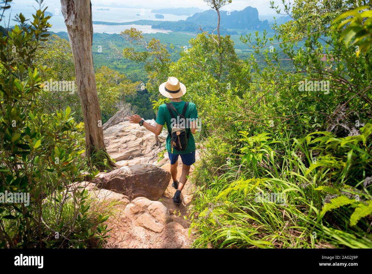 Traveler passeggiate lungo il sentiero roccioso nella foresta tropicale con panorama mozzafiato sul mare e di gran lunga al di sotto sull'orizzonte, a Krabi, Thailandia. Khao Ngon Nak Sentiero Natura Foto Stock