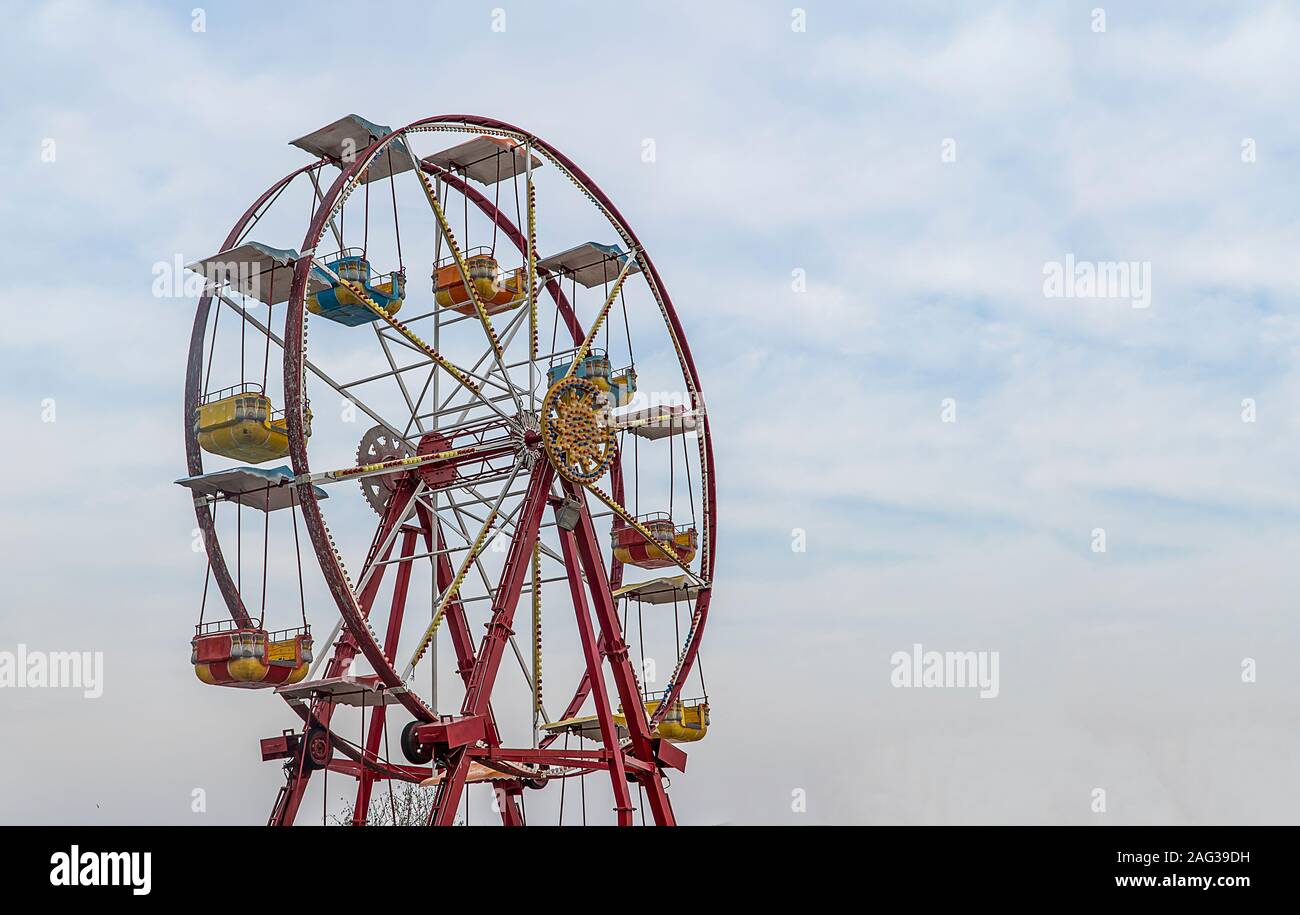 Coloratissima ruota panoramica Ferris su sfondo con cielo nuvoloso Foto Stock