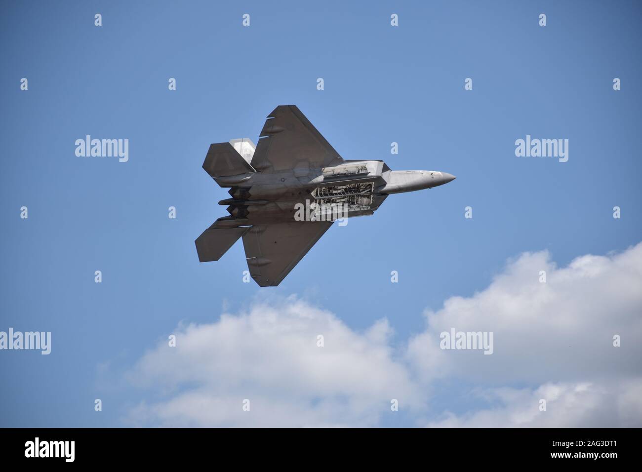 Caccia jet manovrando nel cielo con alcune nuvole nella parte inferiore dell'immagine Foto Stock