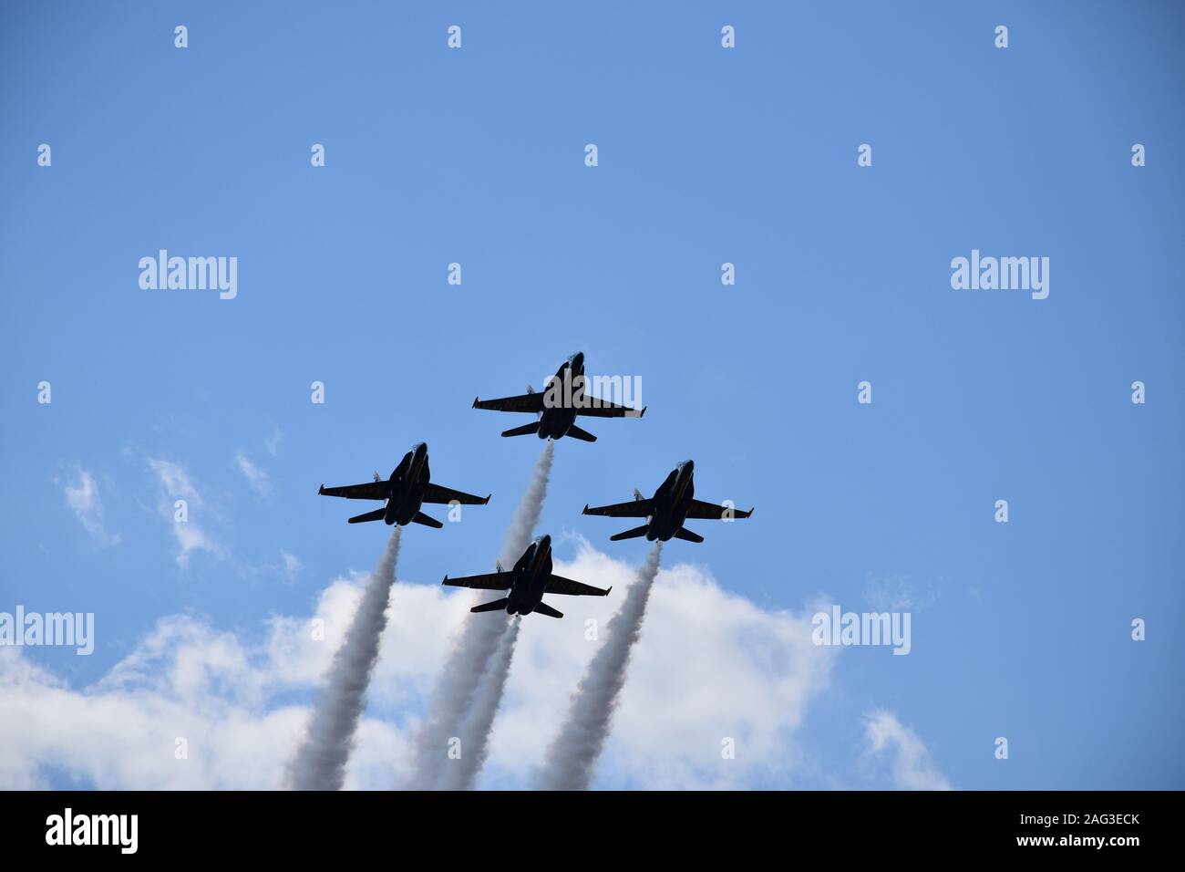 Una bassa angolazione di quattro jet da combattimento con grandi percorsi maneuvring nel cielo durante un air show Foto Stock