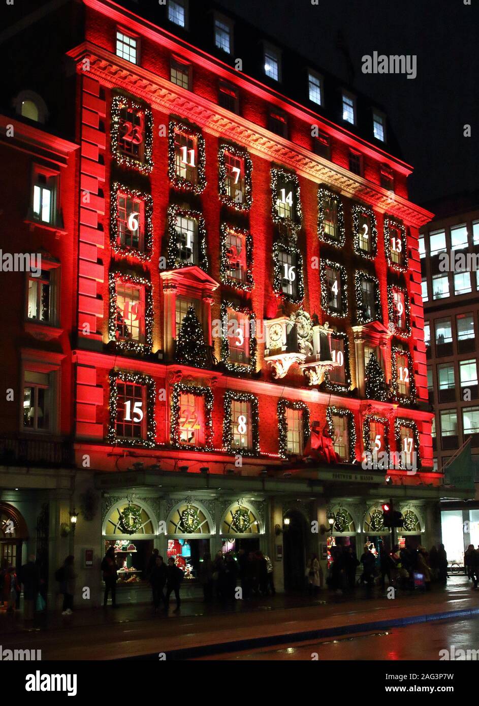 London sistemazione department store Fortnum & Mason a Piccadilly è stata trasformata in un gigantesco calendario dell'avvento di questo Natale. La sua facciata iconico è bagnata in rosso con le sue finestre decorate e numerati come un tradizionale calendario dell'Avvento. La finestra Visualizza si trovano anche alcuni dei migliori nella capitale per la stagione festiva. Foto Stock