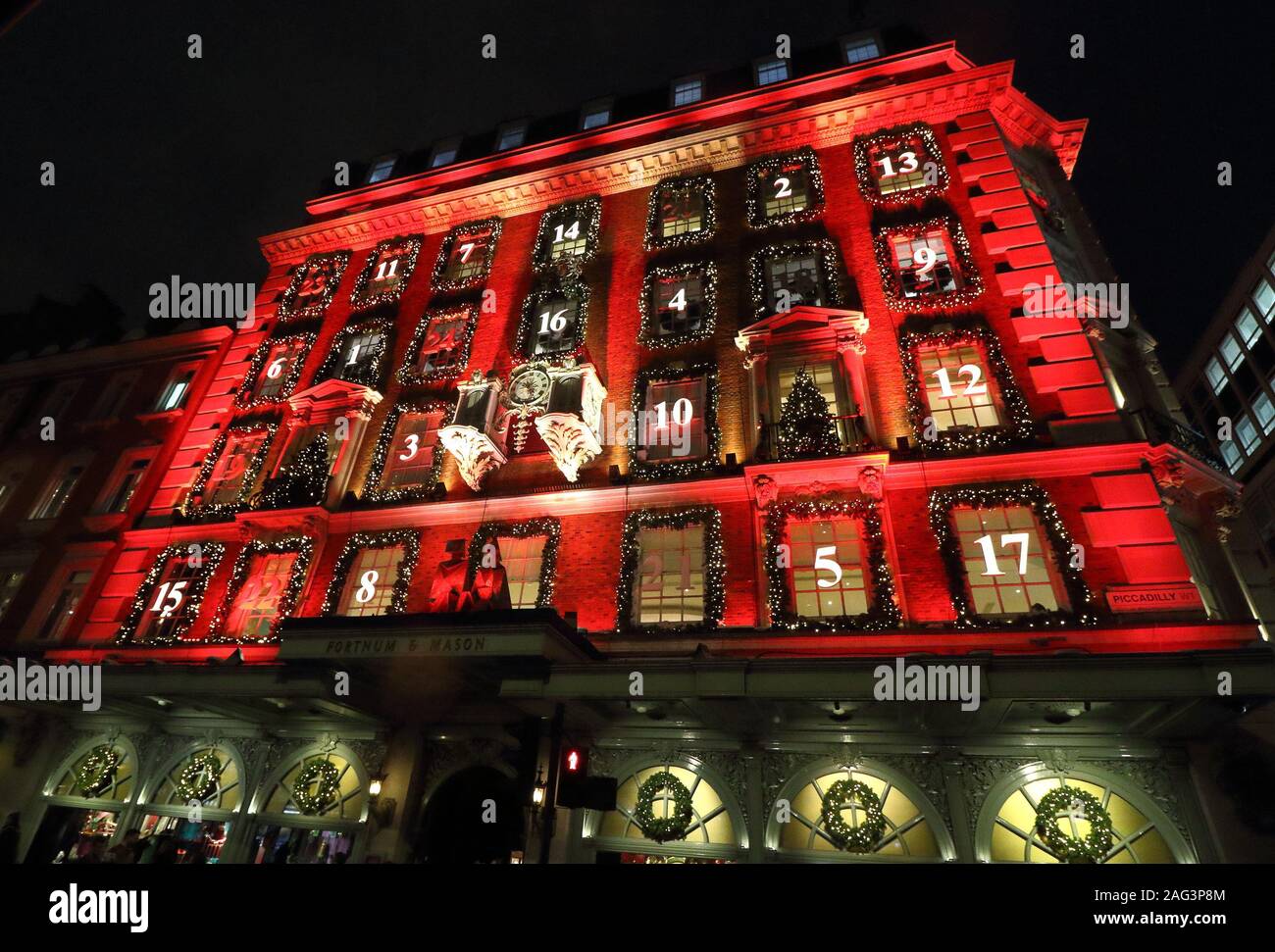 London sistemazione department store Fortnum & Mason a Piccadilly è stata trasformata in un gigantesco calendario dell'avvento di questo Natale. La sua facciata iconico è bagnata in rosso con le sue finestre decorate e numerati come un tradizionale calendario dell'Avvento. La finestra Visualizza si trovano anche alcuni dei migliori nella capitale per la stagione festiva. Foto Stock