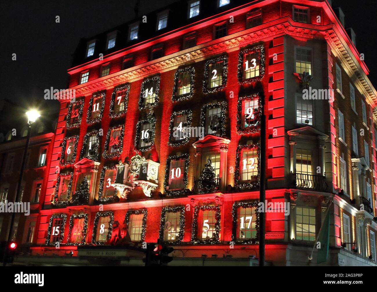 London sistemazione department store Fortnum & Mason a Piccadilly è stata trasformata in un gigantesco calendario dell'avvento di questo Natale. La sua facciata iconico è bagnata in rosso con le sue finestre decorate e numerati come un tradizionale calendario dell'Avvento. La finestra Visualizza si trovano anche alcuni dei migliori nella capitale per la stagione festiva. Foto Stock