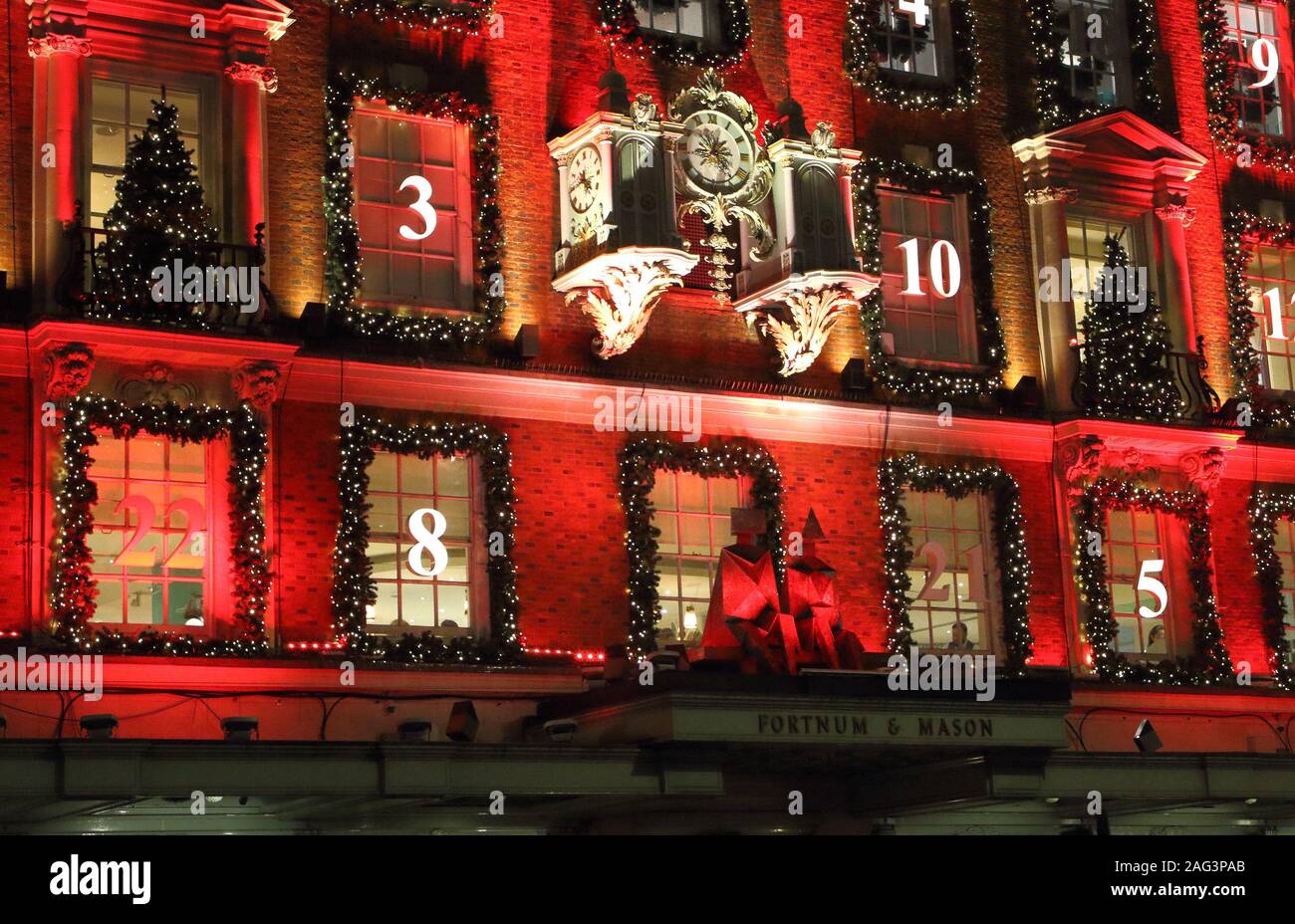 London sistemazione department store Fortnum & Mason a Piccadilly è stata trasformata in un gigantesco calendario dell'avvento di questo Natale. La sua facciata iconico è bagnata in rosso con le sue finestre decorate e numerati come un tradizionale calendario dell'Avvento. La finestra Visualizza si trovano anche alcuni dei migliori nella capitale per la stagione festiva. Foto Stock