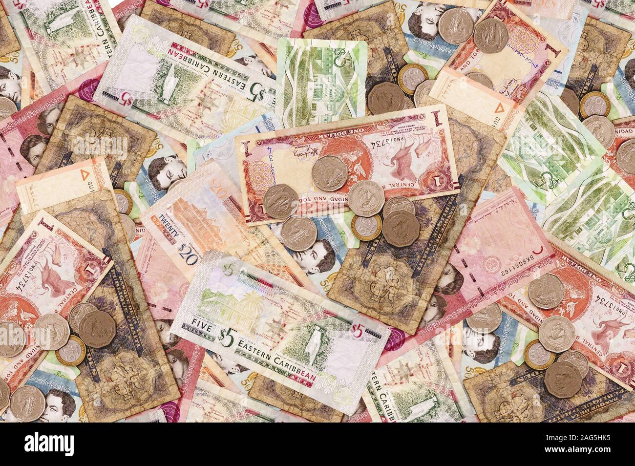 Scatto ad alto angolo di molte banconote e monete posate sopra il concetto di base - corruzione Foto Stock