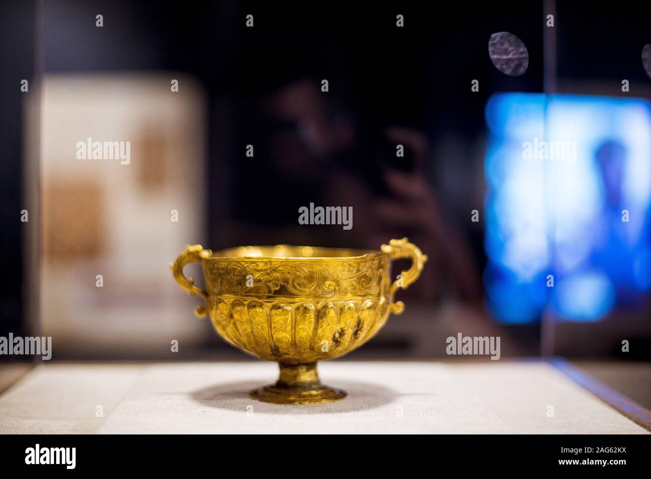 Primo piano di una bella vecchia tazza religiosa di ottone con motivi su uno sfondo sfocato Foto Stock