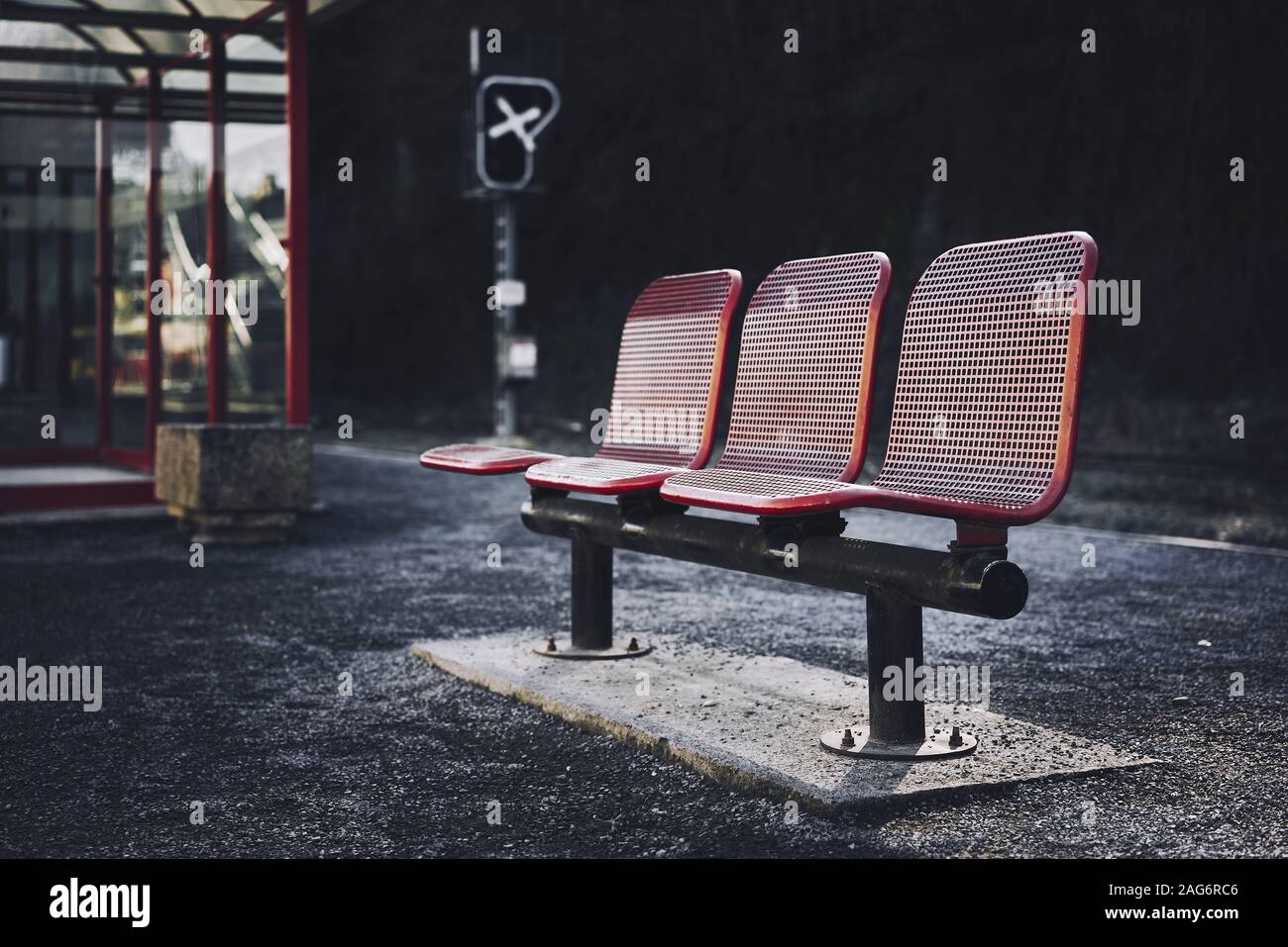 Bellissimo scatto di tre posti rossi nella stazione degli autobus di un'area urbana Foto Stock