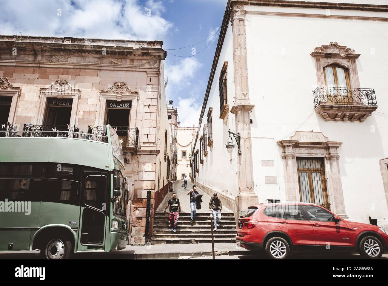 ZACATECAS, Messico - Nov 11, 2019: Messico Street Alley con autobus, auto e persone a piedi. Green bus & auto rossa. La foto in orizzontale Foto Stock