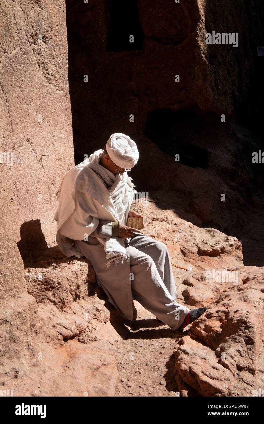 Etiopia, Amhara Region, Lalibela, Bet Maryam cortile della chiesa, devoto lettura vangelo nella luce del sole Foto Stock