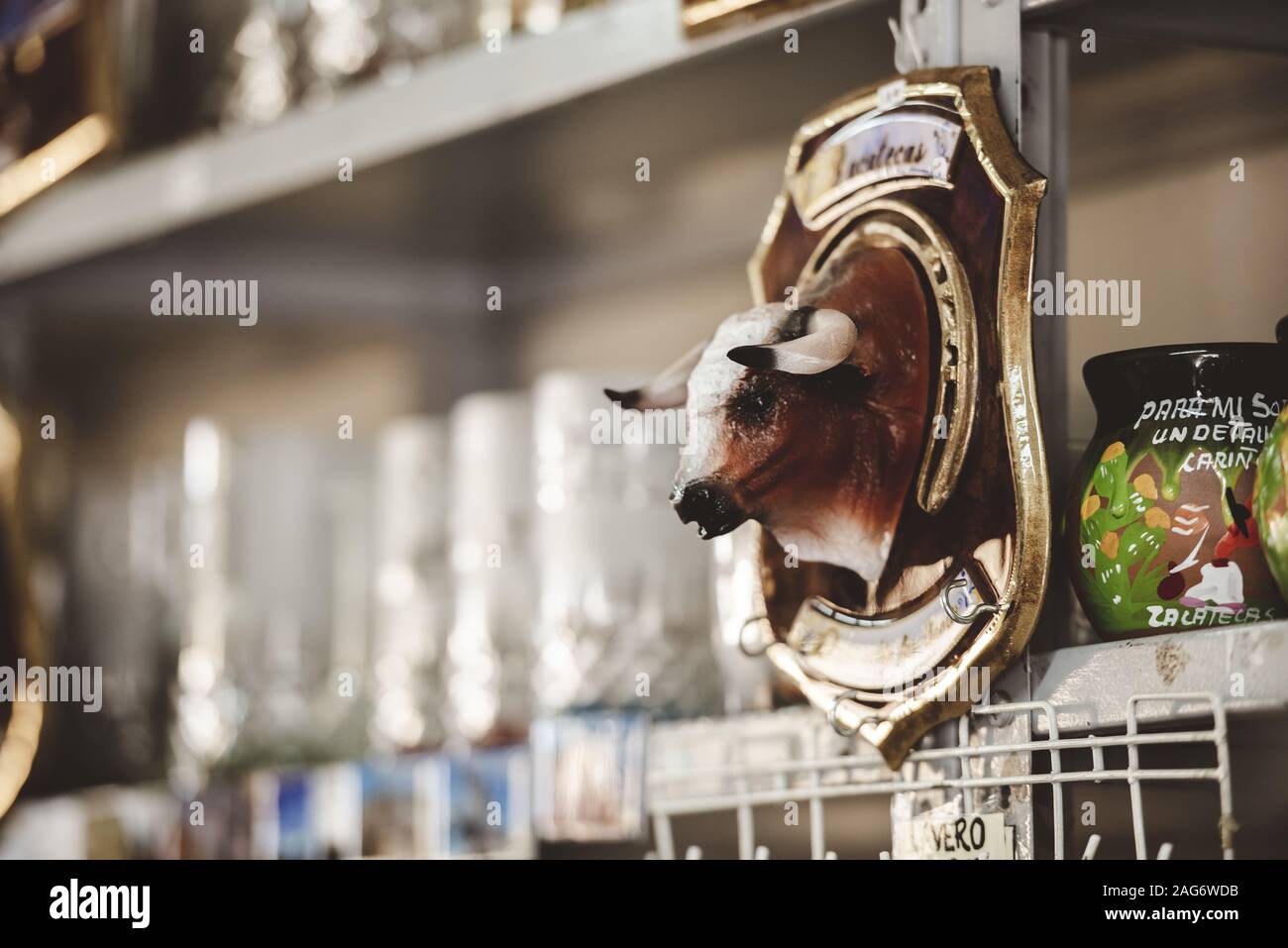 Primo piano di una testa di toro decorativa attaccata al scaffale nel negozio Foto Stock