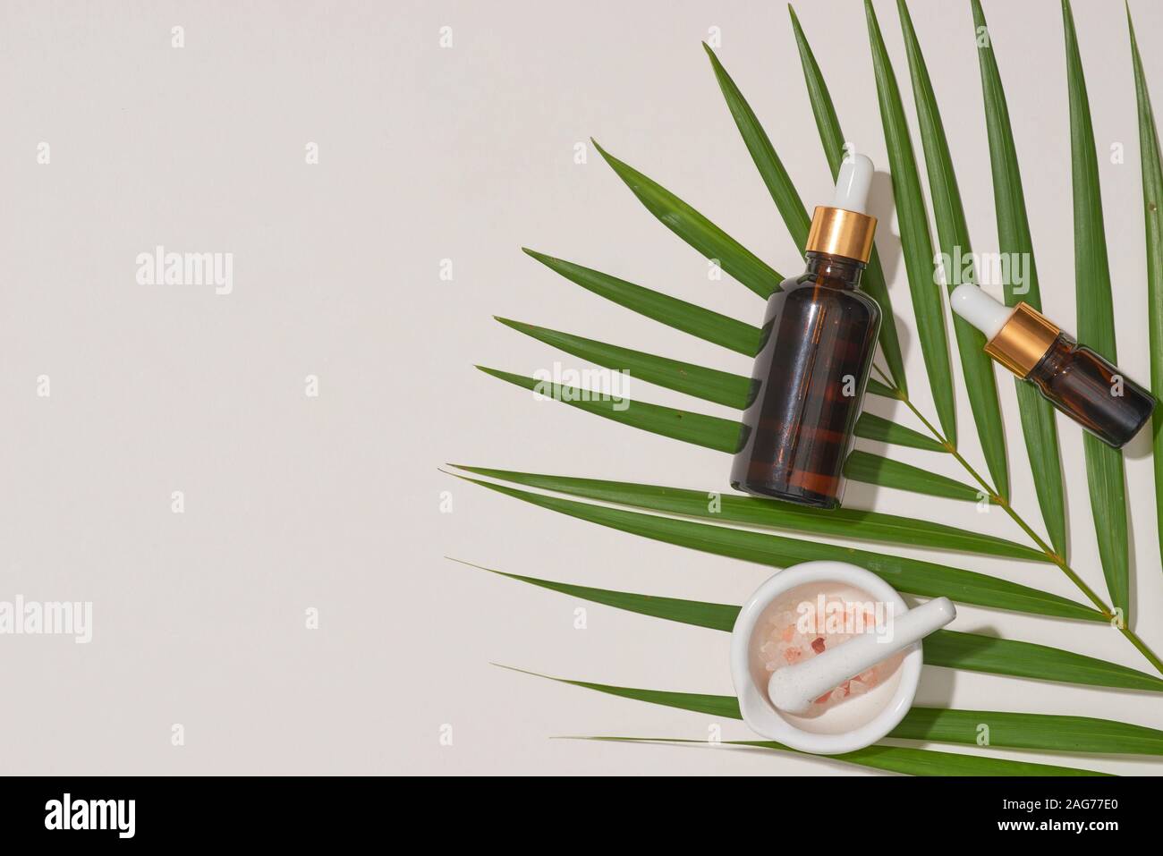 Concetto di spa con massaggi, sale in cucchiaio e bottiglie di olio essenziale con piccole lasciare Foto Stock