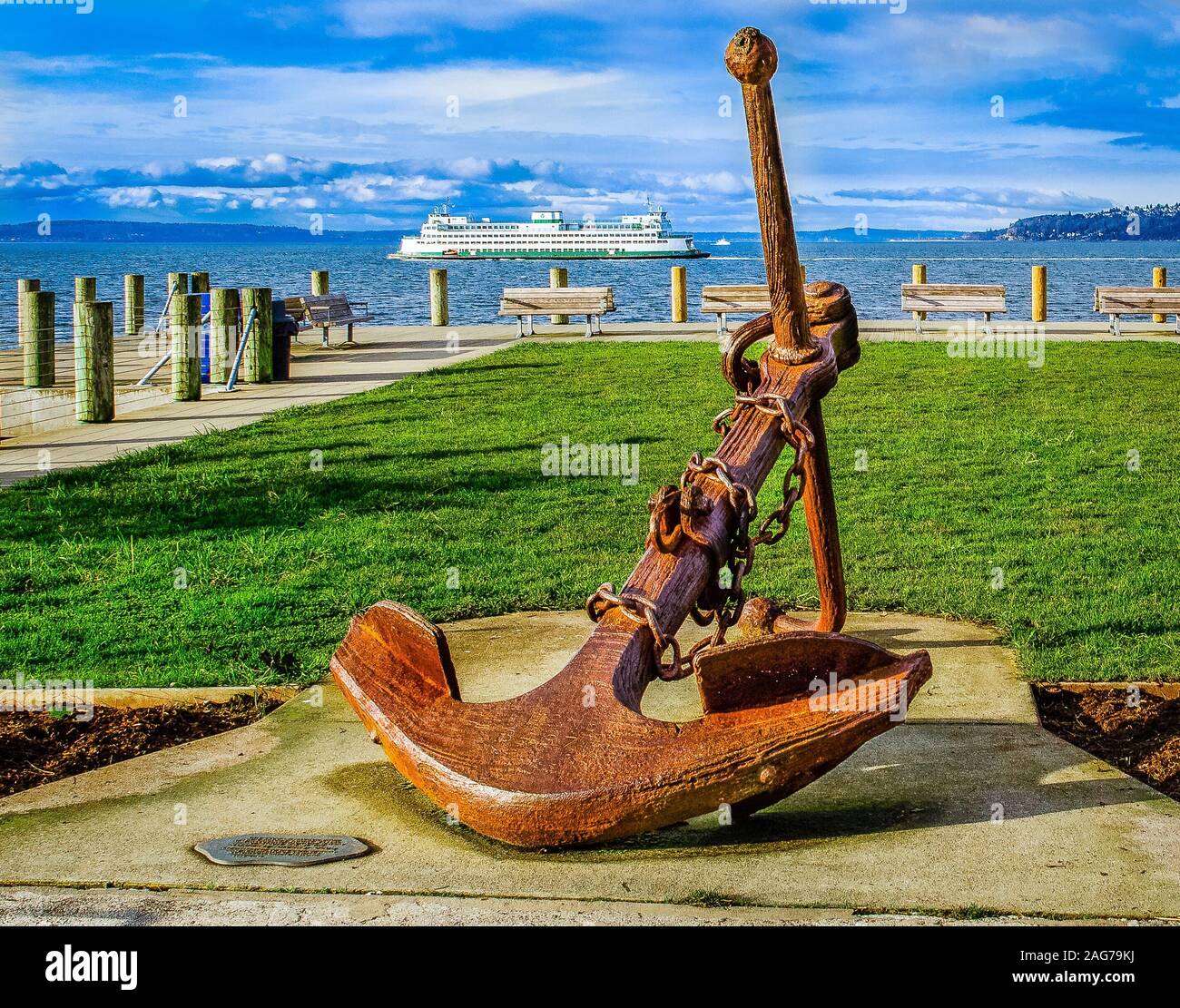 Ancora metallica sulla spiaggia con una nave da crociera il mare e le nuvole nel cielo Foto Stock