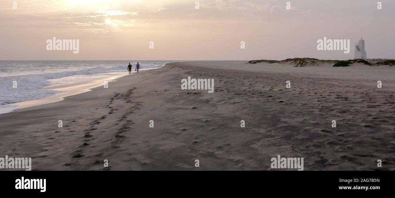 Un paio di godere di un tramonto a piedi su di una spiaggia appartata in Capo Verde Foto Stock