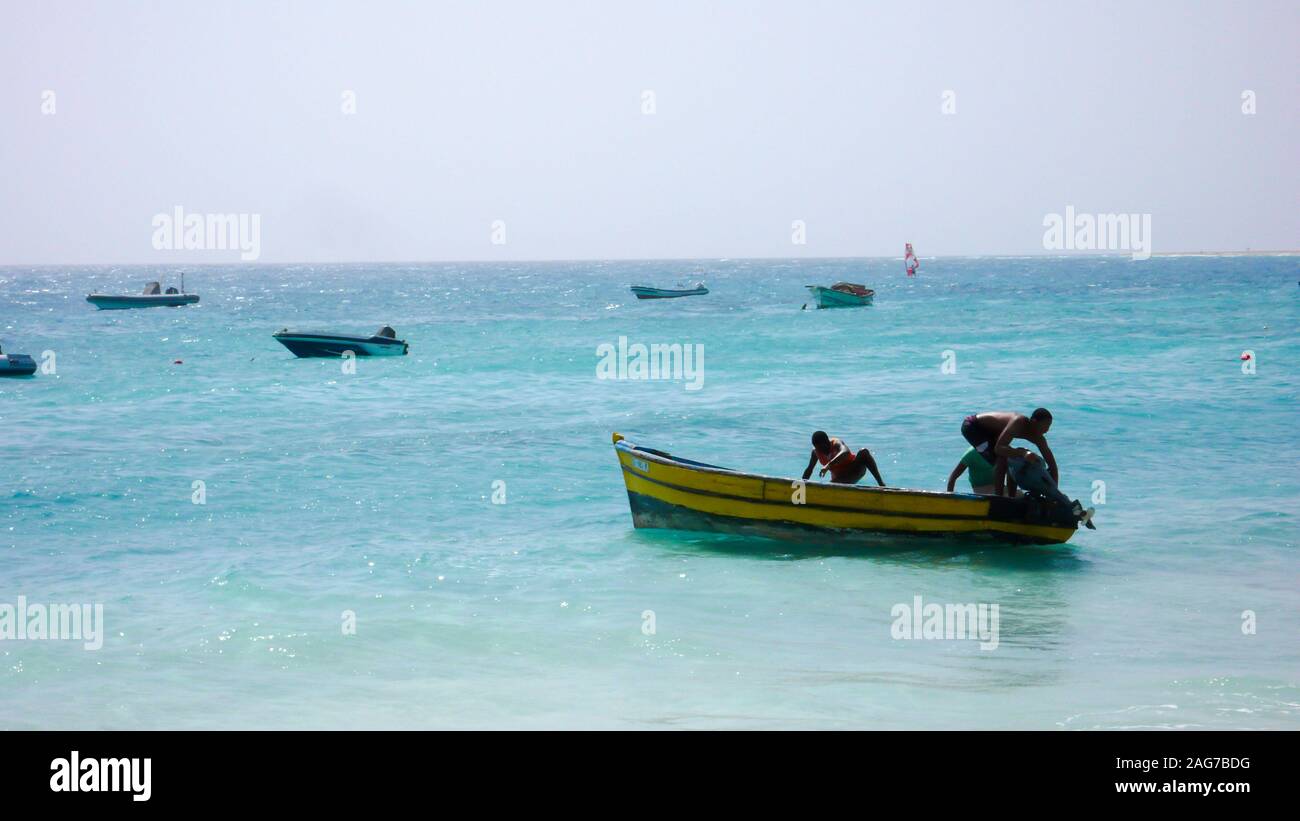 Santa Maria, Sal /Isole di Capo Verde - 19. Novembre, 2015: i pescatori africani il lancio di piccolo skiff di legno da una spiaggia tropicale sulle Isole di Capo Verde Foto Stock