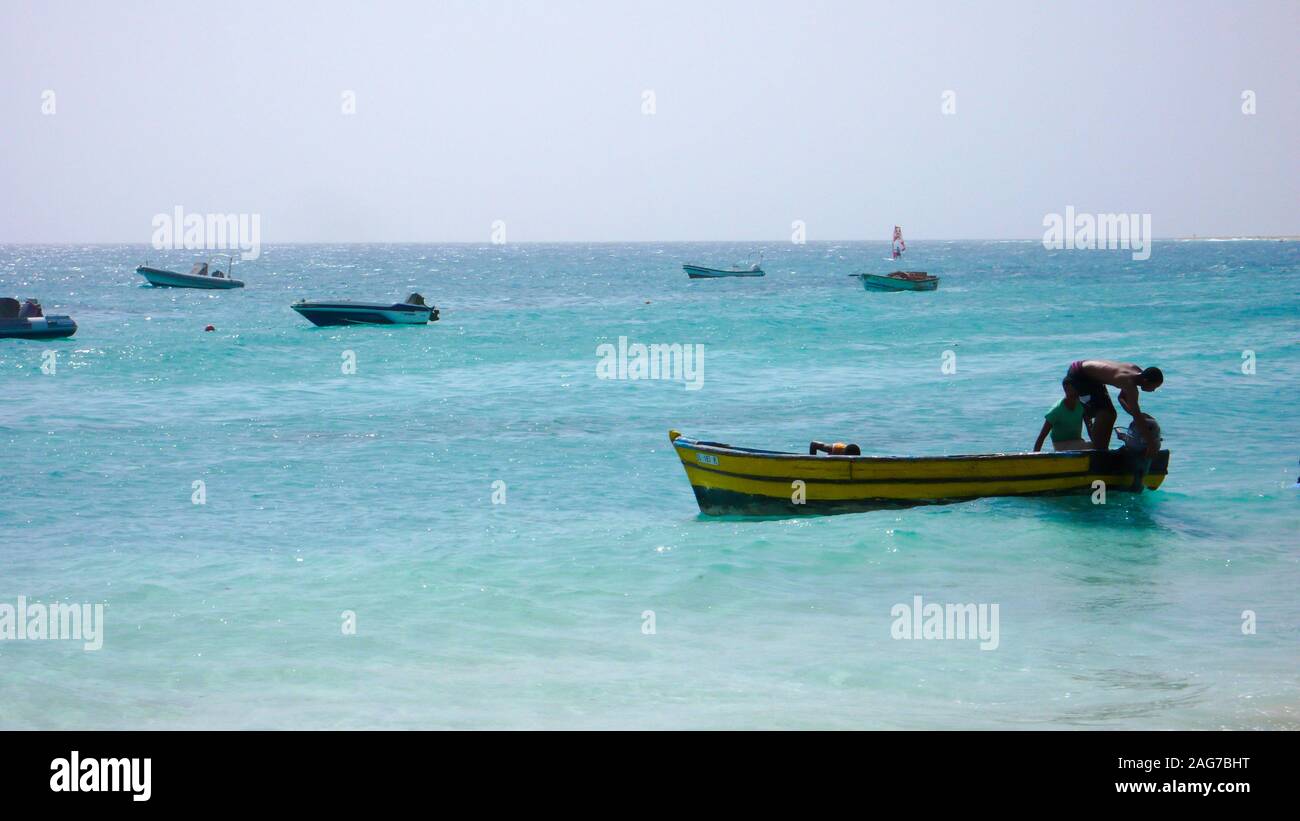 Santa Maria, Sal /Isole di Capo Verde - 19. Novembre, 2015: i pescatori africani il lancio di piccolo skiff di legno da una spiaggia tropicale sulle Isole di Capo Verde Foto Stock
