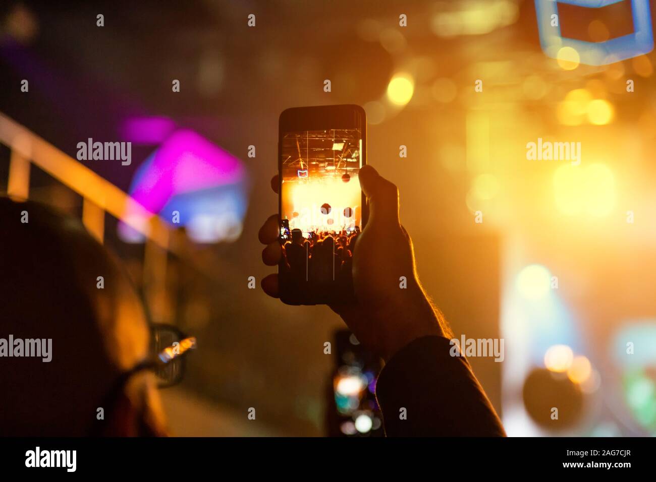 Il visualizzatore in un night club tiene un concerto su uno smartphone. Foto Stock