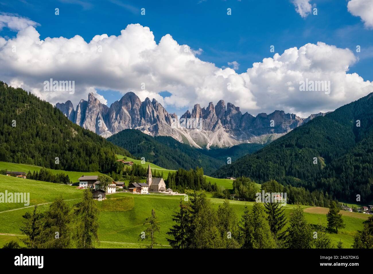 Il villaggio e la vecchia chiesa parrocchiale Santa Maddalena alla fine della Val di Funes e Val di Funes, i vertici delle Odle, Gruppo delle Odle Foto Stock