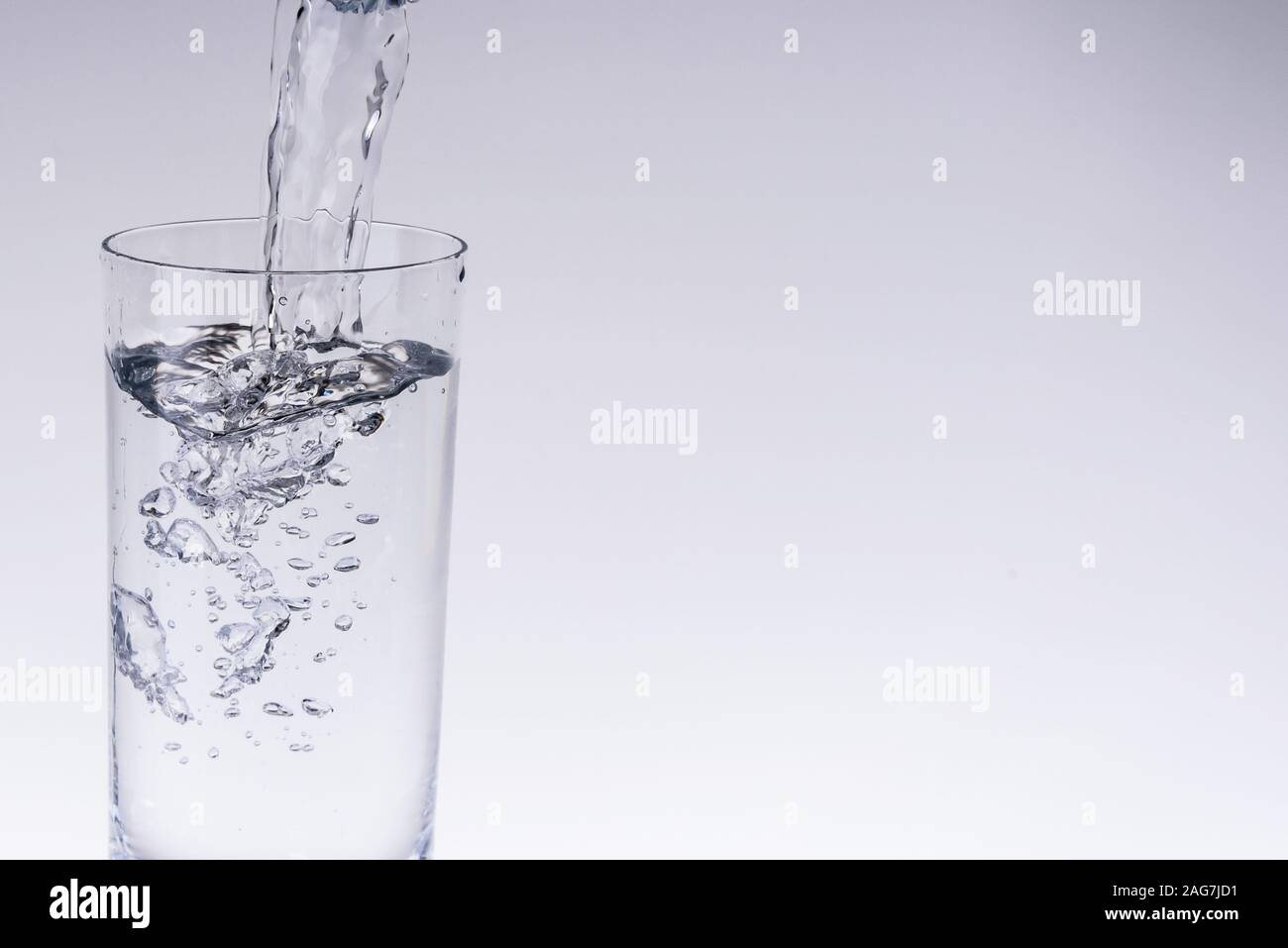 Riempire il bicchiere di acqua dal filtro dell'acqua Foto Stock