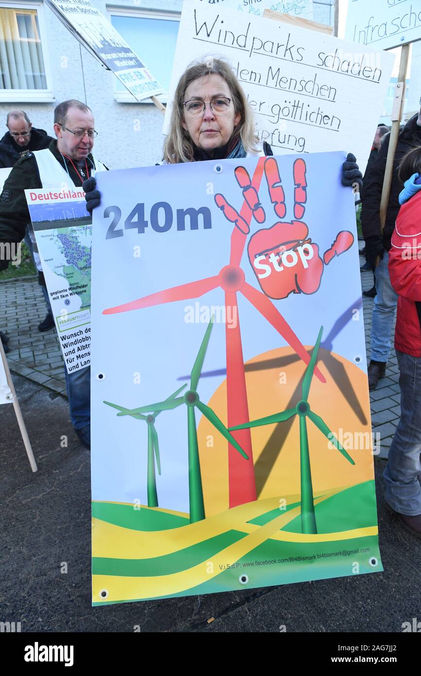 Greifswald (Germania). Xviii Dicembre, 2019. Una donna protesta con un poster contro l ulteriore espansione del potere di vento nei pressi dei villaggi. Secondo gli oppositori dell'energia eolica, la pianificazione regionale associazione vuole onda attraverso tutti vento previste aree di idoneità. Credito: Stefan Sauer/dpa-Zentralbild/dpa/Alamy Live News Foto Stock