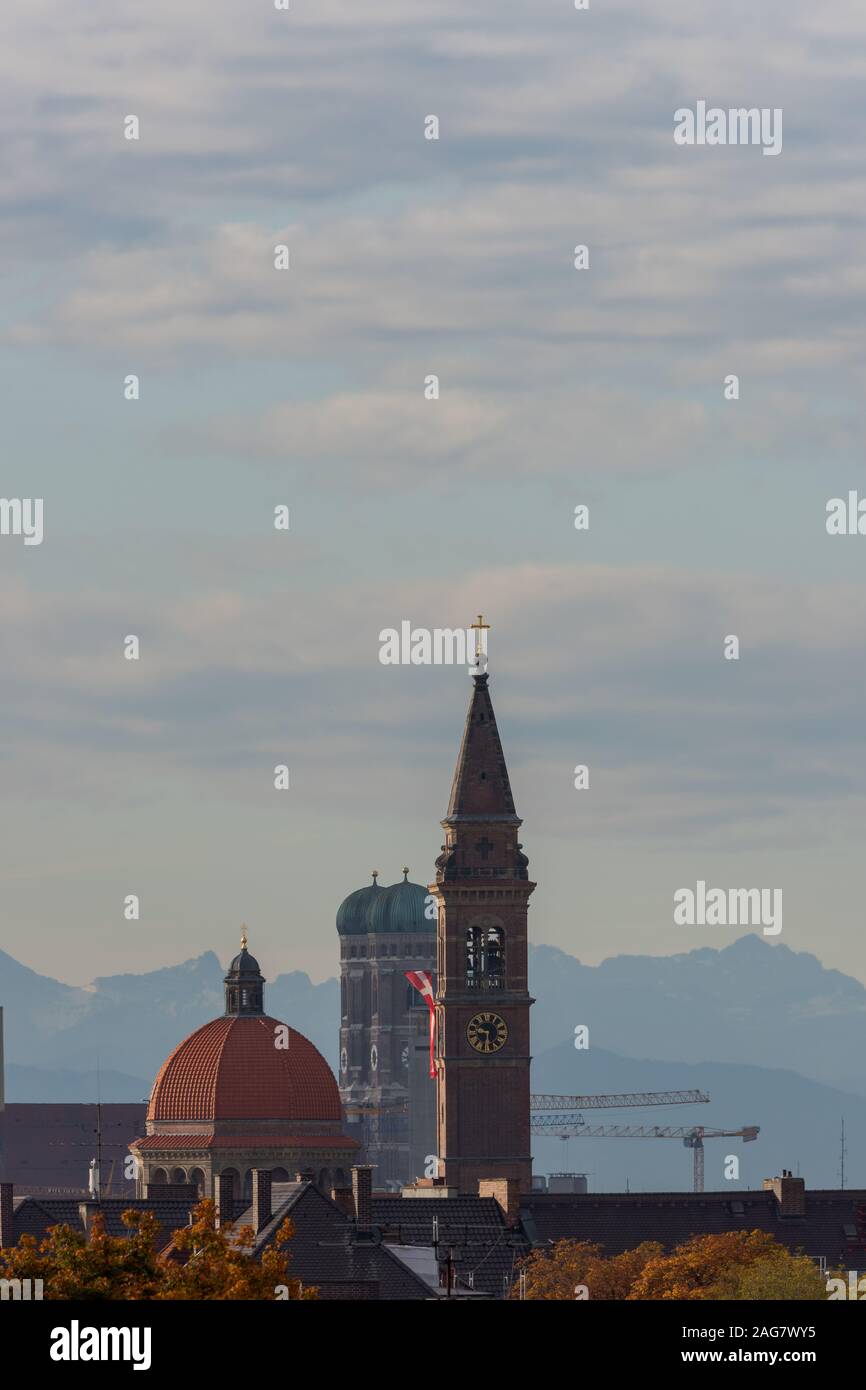 Vista sul tetto delle chiese di Monaco di Baviera con montagne alpine in background Foto Stock