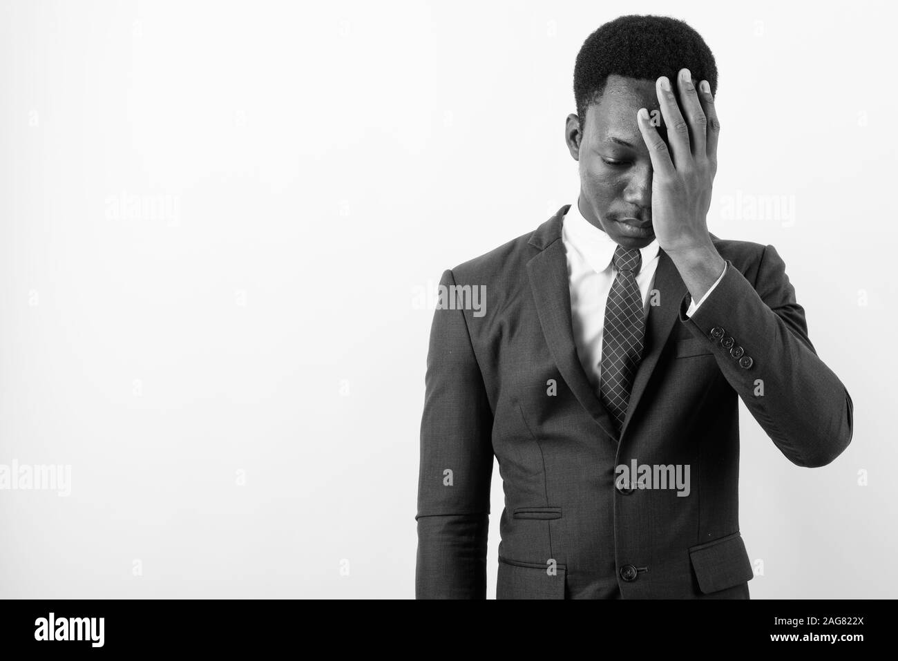 Bel giovane imprenditore africano indossare tuta contro uno sfondo bianco Foto Stock