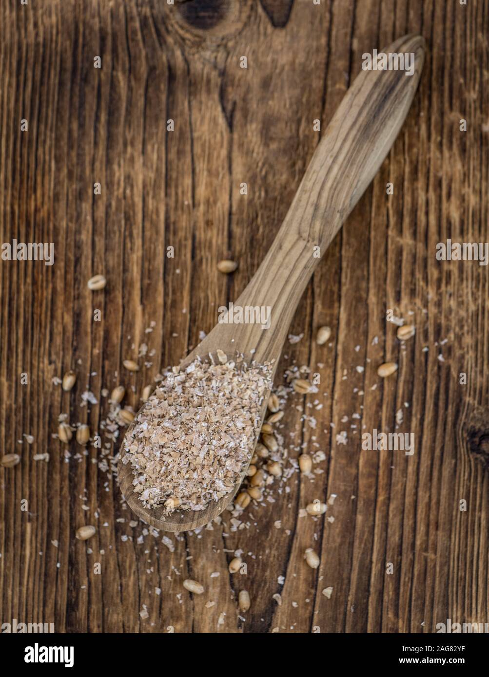 Crusca di frumento su un vecchio tavolo di legno (messa a fuoco selettiva) Foto Stock
