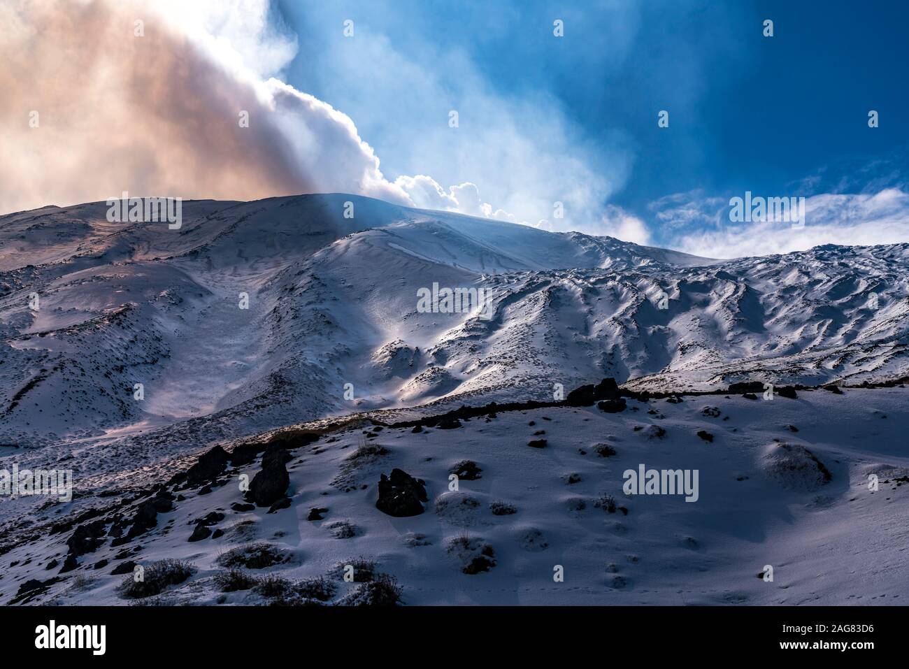 Die Sonne scheint durch die Wolken über dem schneebedeckten Vulkan Ätna, Sizilien, Italien, Europa | il sole che splende attraverso le nuvole sulla neve Foto Stock