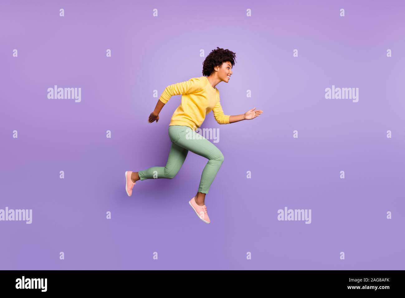 Completa il profilo del corpo foto a lato positivo di brunette capelli ricci scuri di pelle ragazza sentire news rientrano gli sconti di primavera salto eseguire indossare pullover giallo Pantaloni verdi Foto Stock