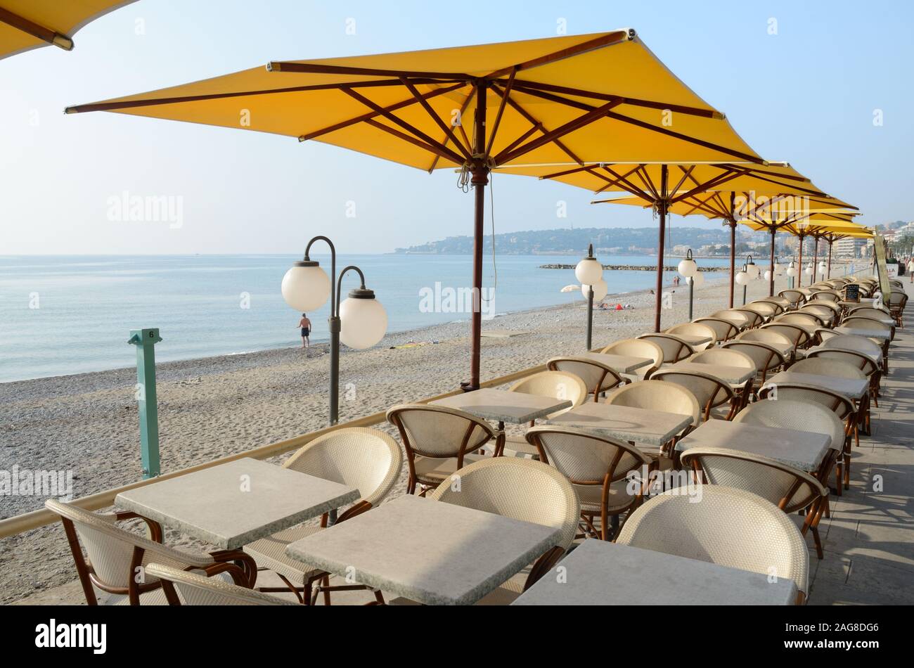 Beach & vuoto ristoranti sul lungomare, tavoli, sedie e ombrelloni Menton Costa azzurra Francia Foto Stock