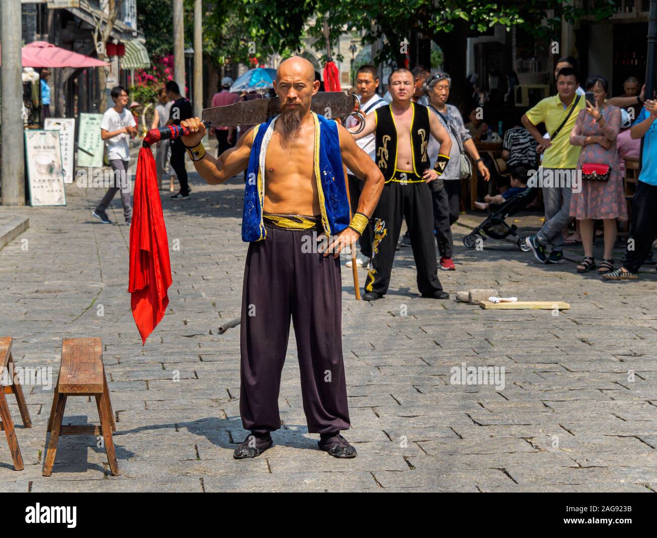 HAINAN, Cina - 3 MAR 2019 - Un asiatico maschio cinese di arti marziali esegue con una spada in costume tradizionale di Feng Antonio filmato storico, Hainan. Foto Stock