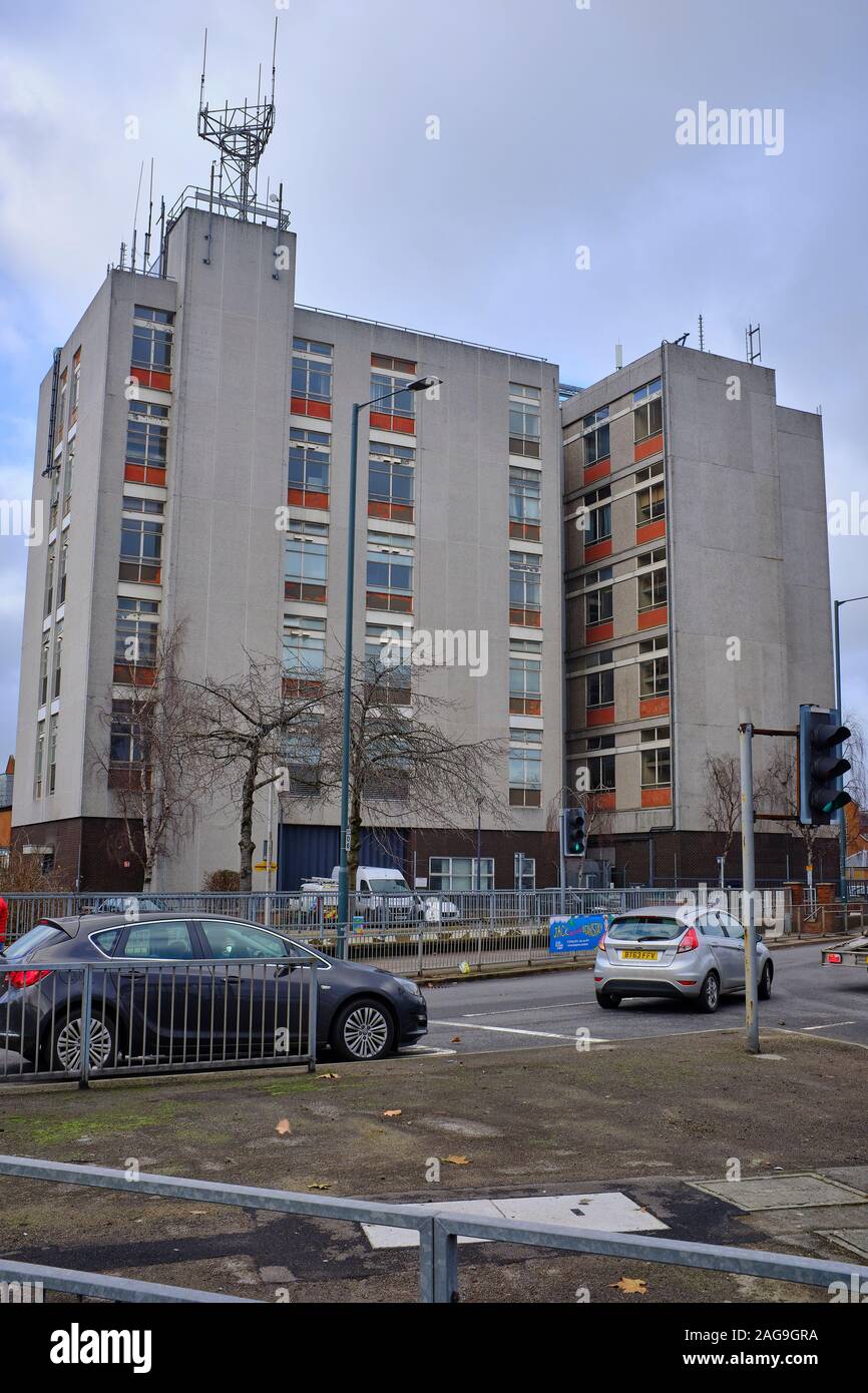 L'edificio Telephone Exchange costruito con cemento a Newbury che ha torri di telefonia mobile in cima con le auto che viaggiano oltre, Newbury, Berkshire, Regno Unito Foto Stock