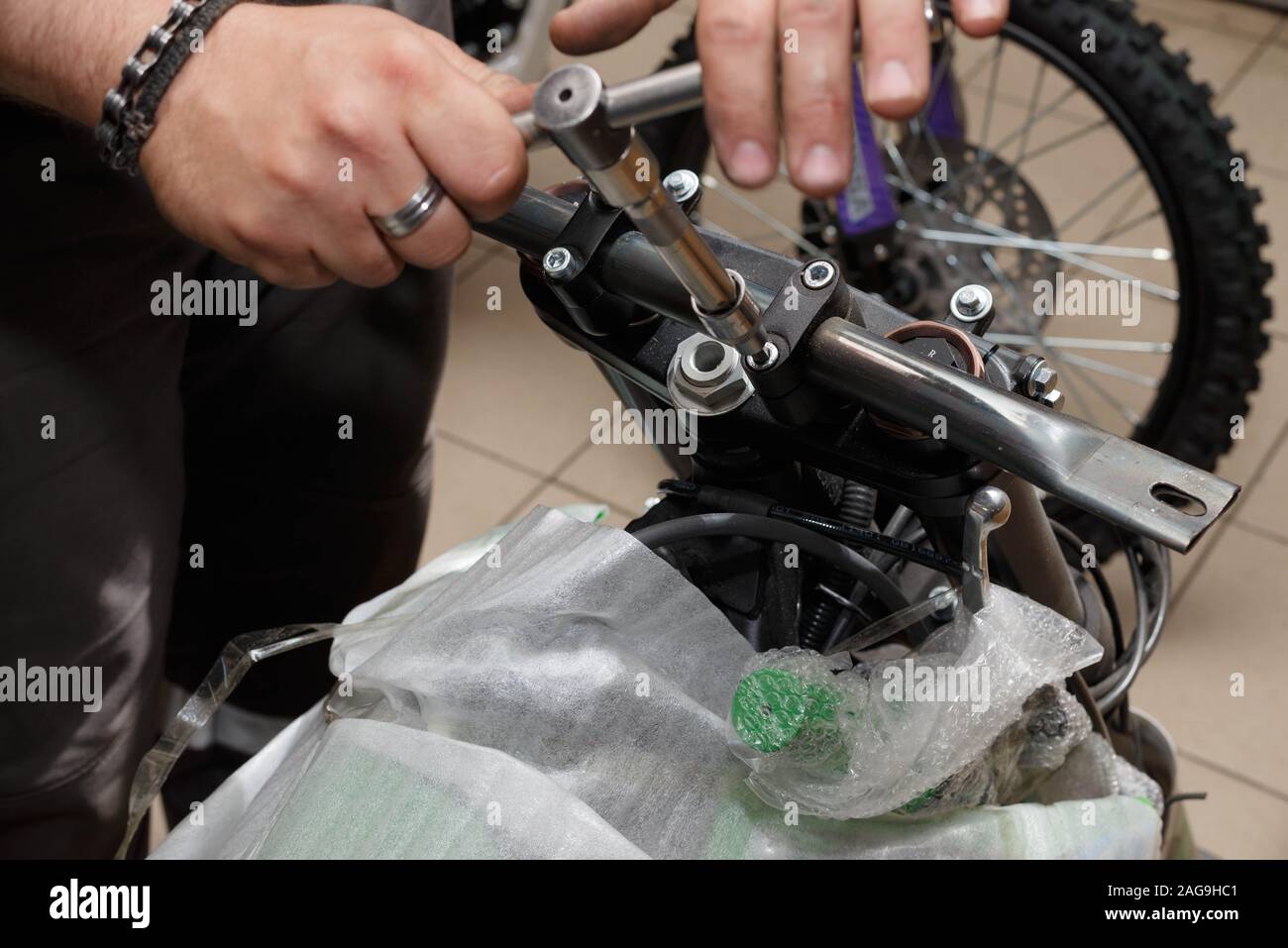 Master raccoglie il motociclo dal contenitore. Il processo di rimozione del attacco rigido per l'installazione del volante di guida di un motociclo. Foto Stock