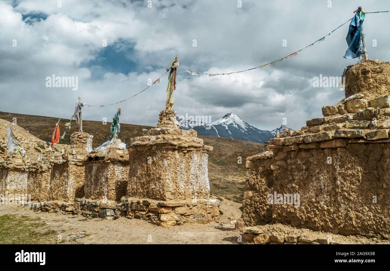 Antichi monumenti buddisti, Chortens e Stupa, con pietra a secco sotto le fondazioni nuvoloso cielo blu d'estate. Tashigang villaggio, Himachal Pradesh, India. Foto Stock