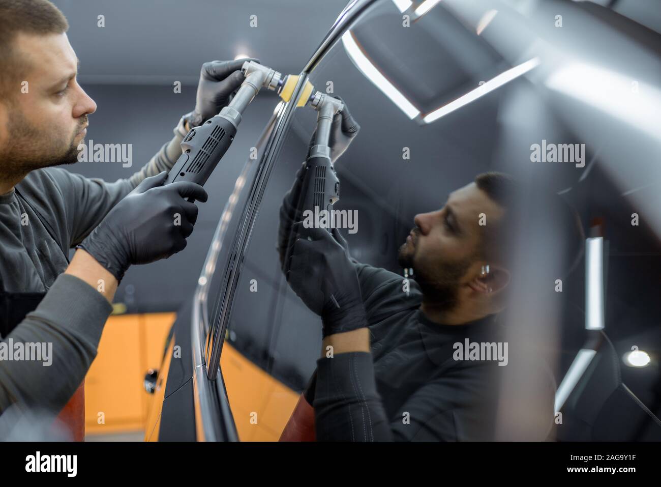 Servizio auto di lavoratore di lucidatura del corpo del veicolo con cera speciale da graffi. Auto professionali di dettagli e concetto di manutenzione Foto Stock