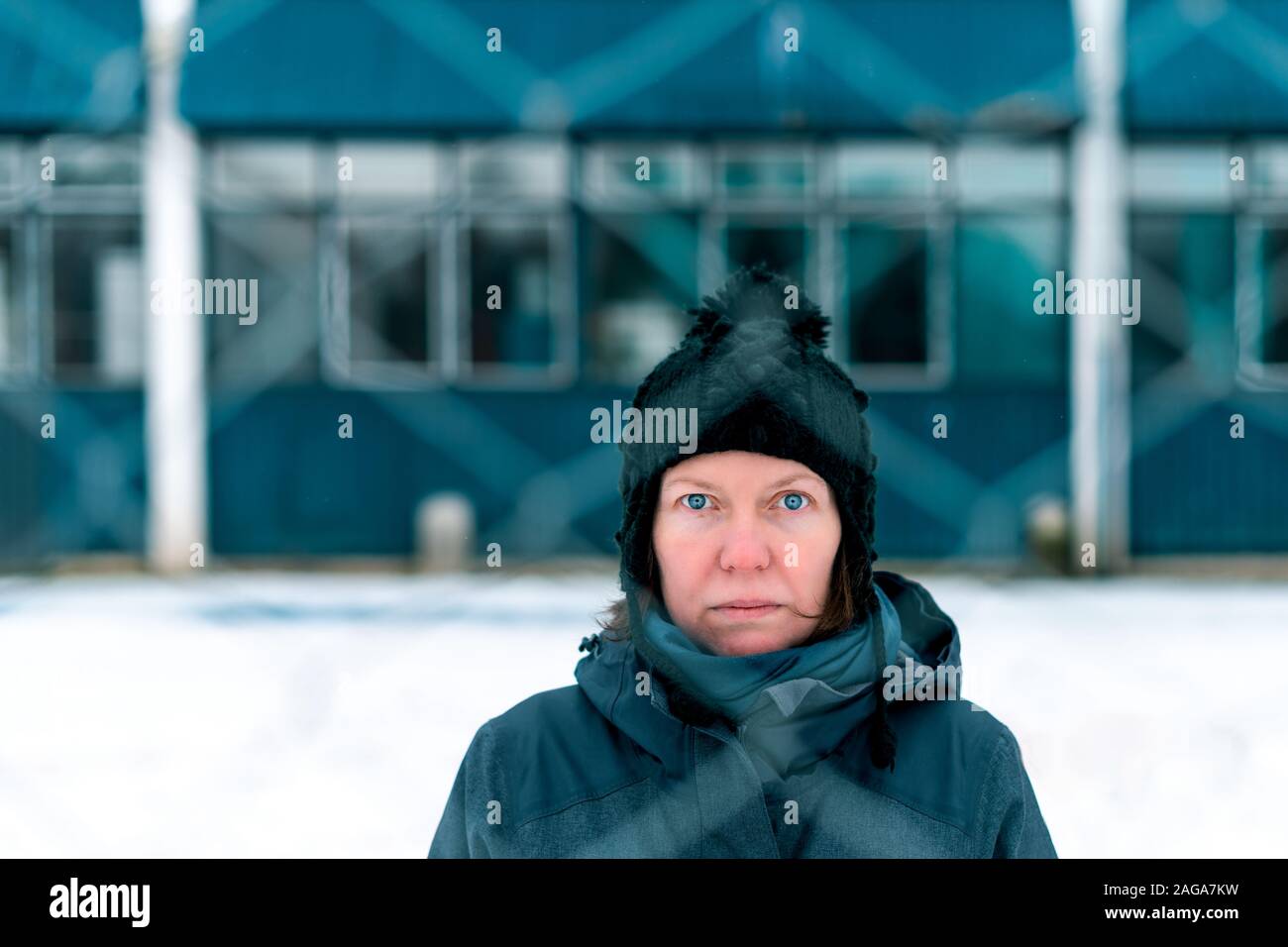 Preoccupato in questione grave donna dietro a catena collegamento recinto come ostacolo sulla fredda giornata invernale Foto Stock