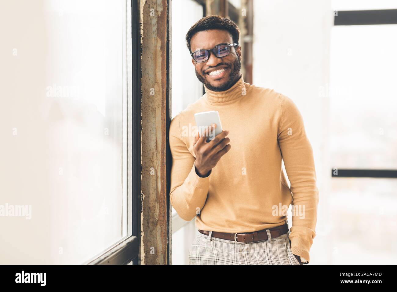 Successo uomo nero in piedi vicino alla finestra di office Foto Stock