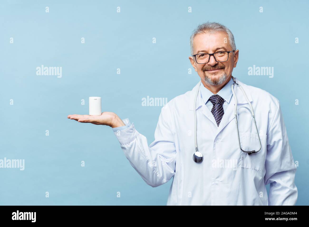 Medico tenendo una bottiglia di pillole su sfondo bianco. Il concetto di medicina, farmacologia, healthcare Foto Stock