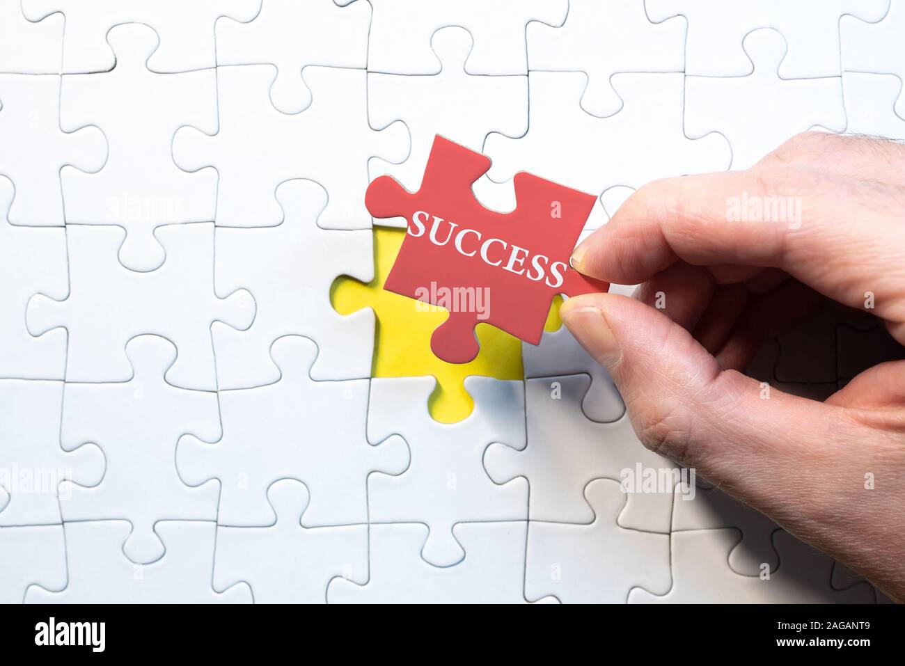 Il successo aziendale concetto, uomo holding ultimo pezzo corrispondente di jigsaw puzzle con successo di parola Foto Stock