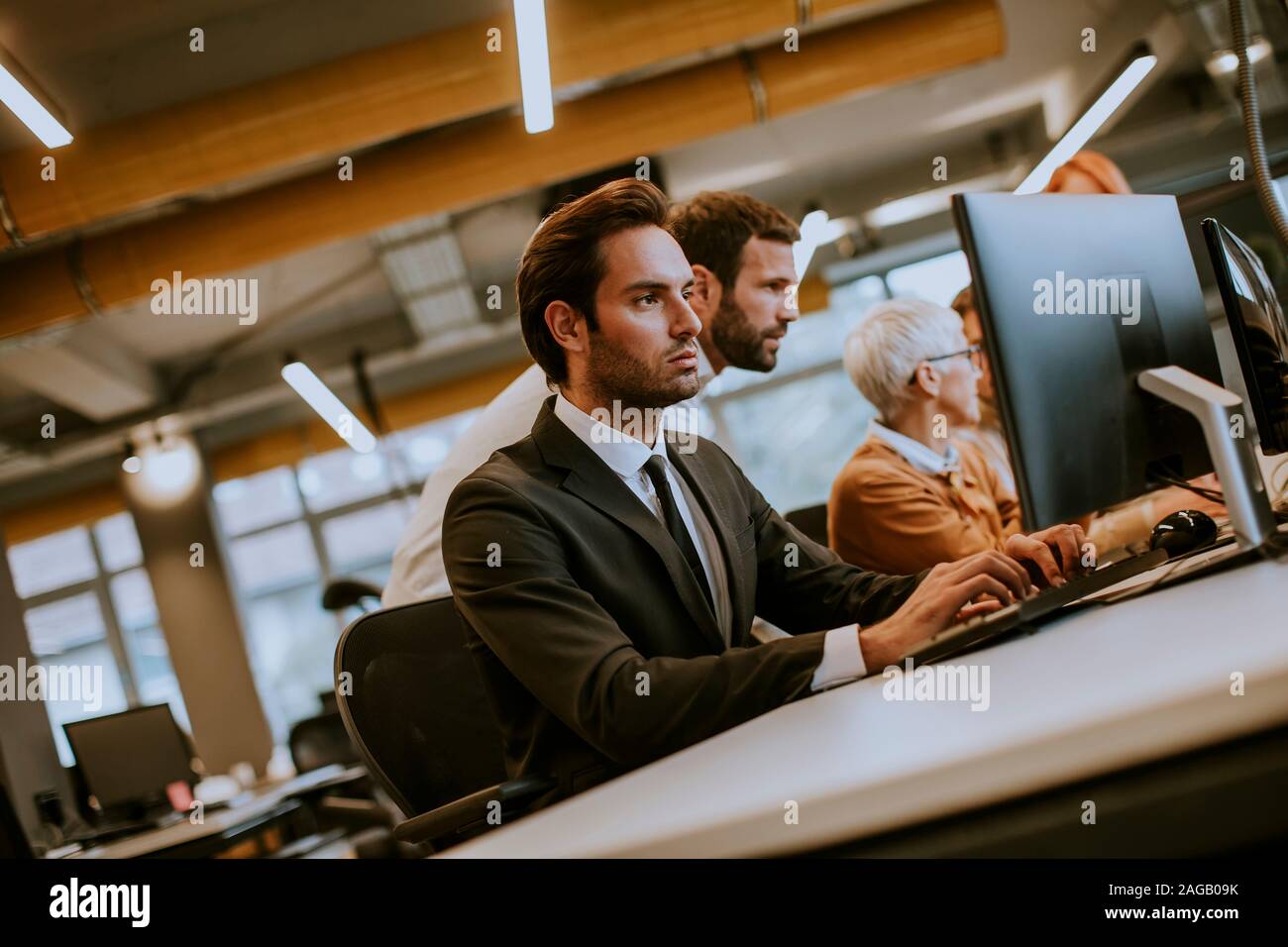 Giovane imprenditore professionale utilizza un computer portatile per il lavoro in ufficio moderno Foto Stock