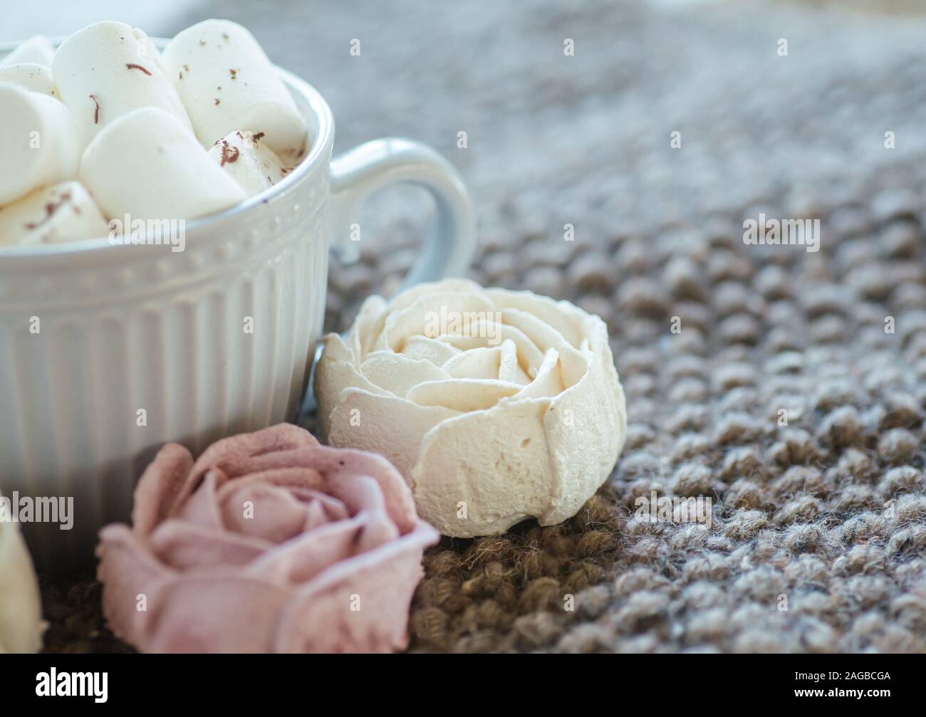 Tazza di cacao o cioccolato accanto a a forma di rosa marshmallow. Caldo accogliente piazza dello sfondo. In casa rosa marshmallow. Presente per la donna il giorno di san valentino Foto Stock