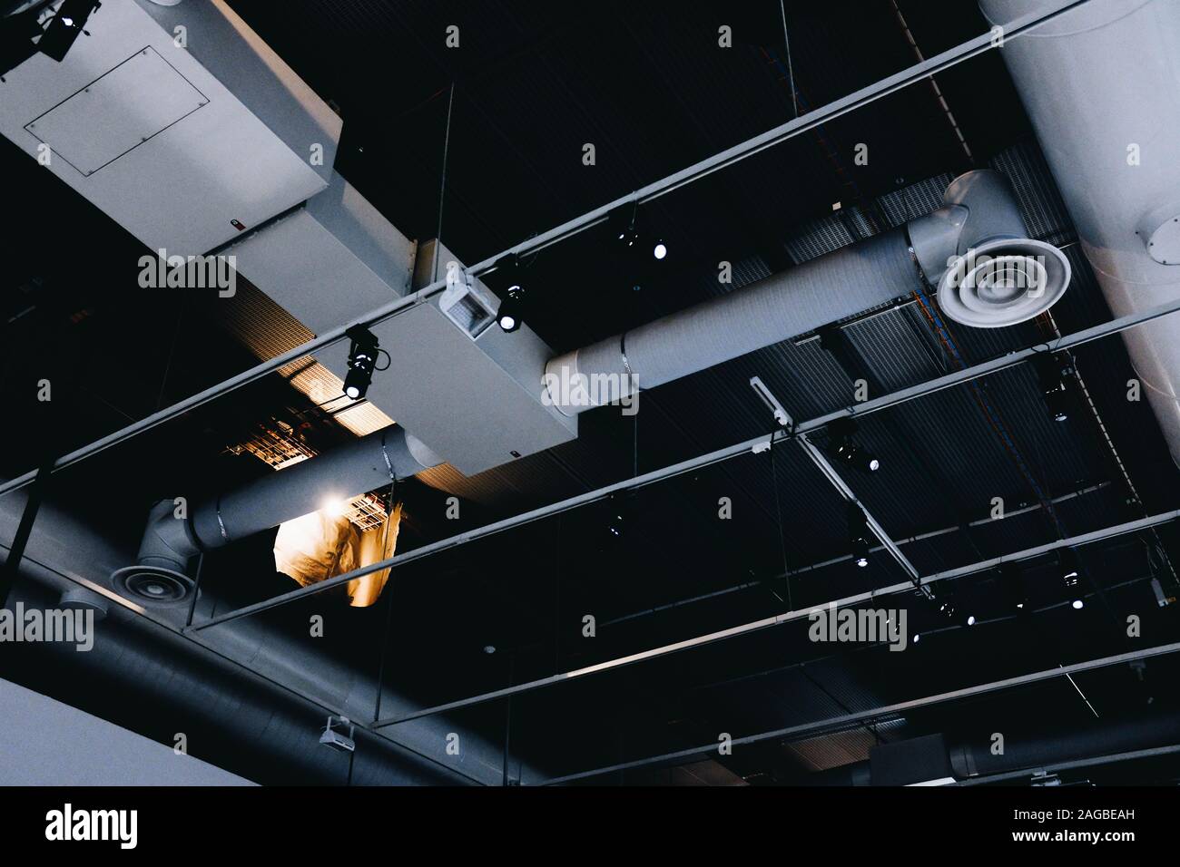 Foto ad angolo ridotto di un soffitto nero in metallo con bianco tubi di ventilazione Foto Stock