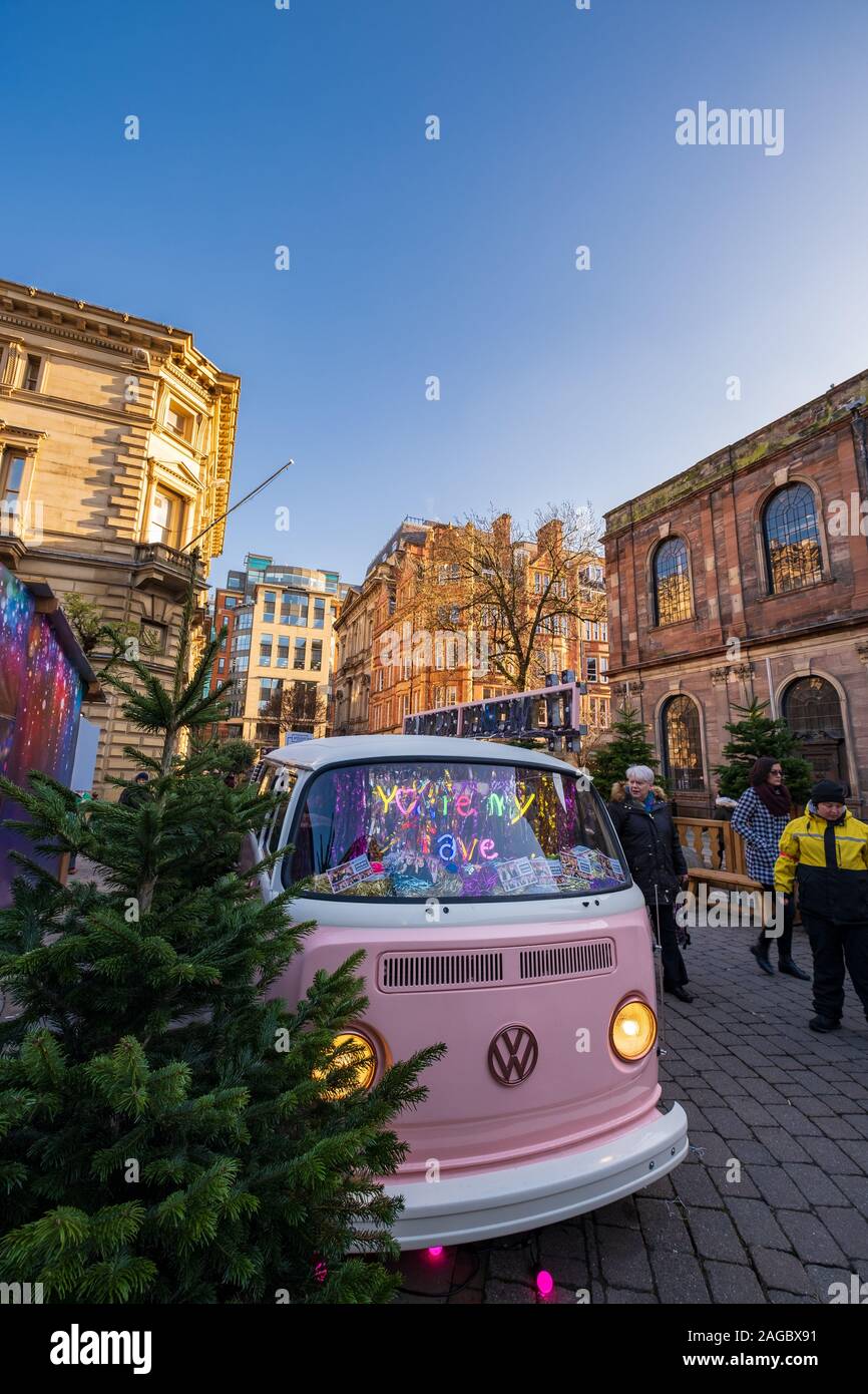 Manchester, Regno Unito - 29 Novembre 2019: mercatini di Natale a Manchester intorno a St rna quadrato con una rosa Volkswagen van in primo piano Foto Stock