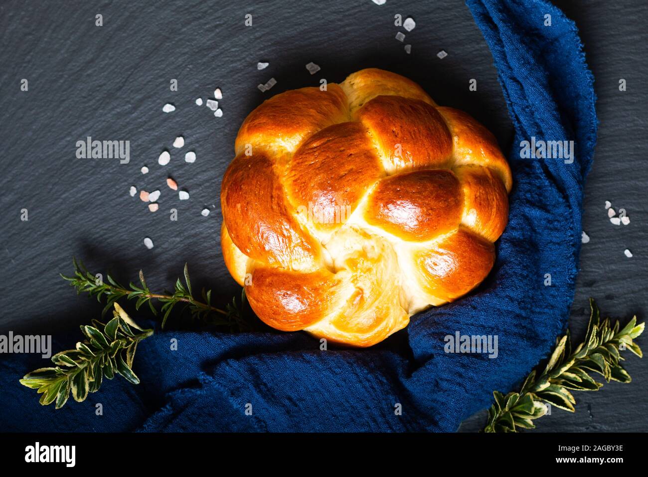 Cibo fatto in casa concetto pane fresco challah treccia o brioche su ardesia nera pietra con spazio di copia Foto Stock