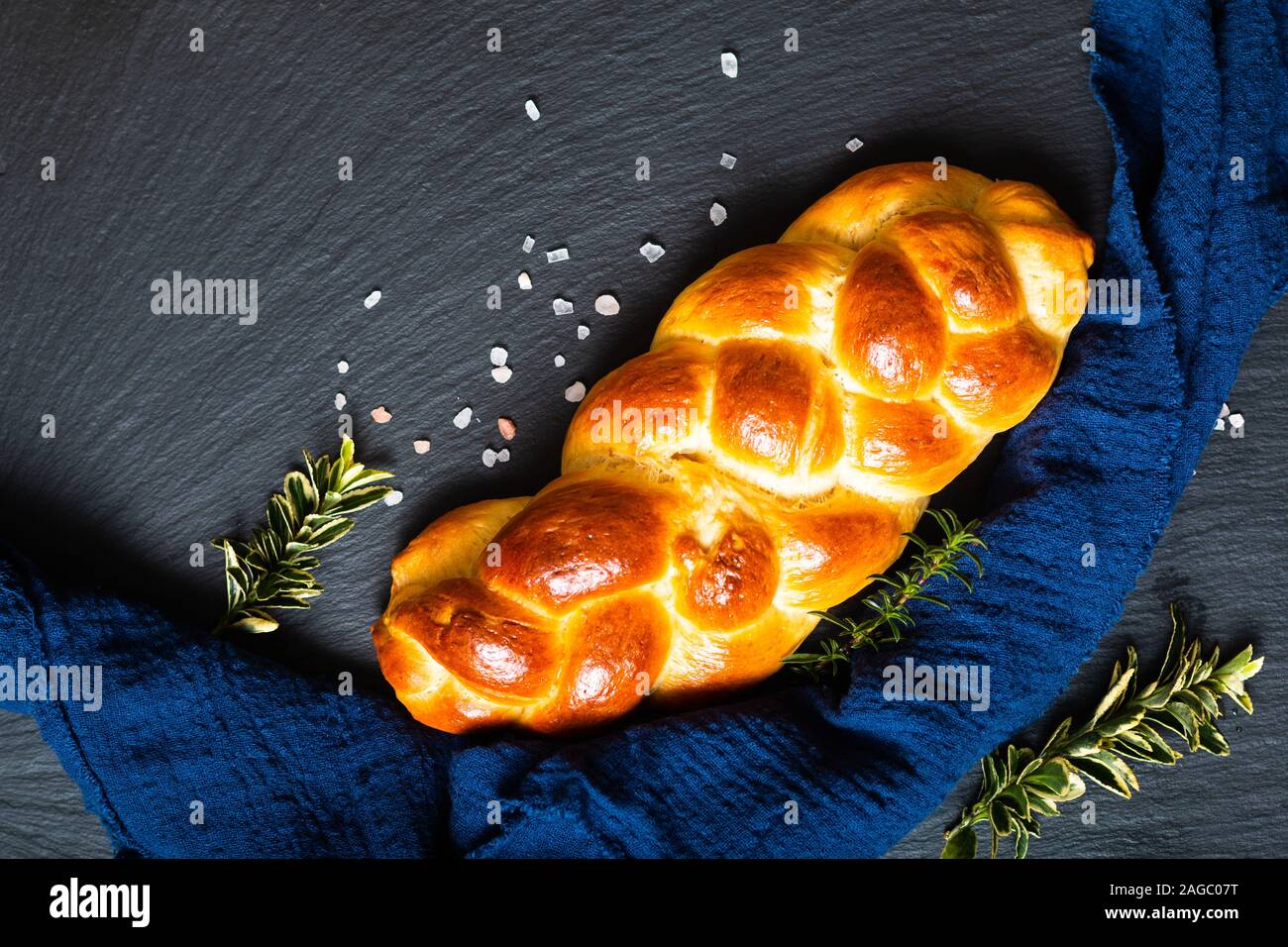 Cibo fatto in casa concetto pane fresco challah treccia o brioche su ardesia nera pietra con spazio di copia Foto Stock