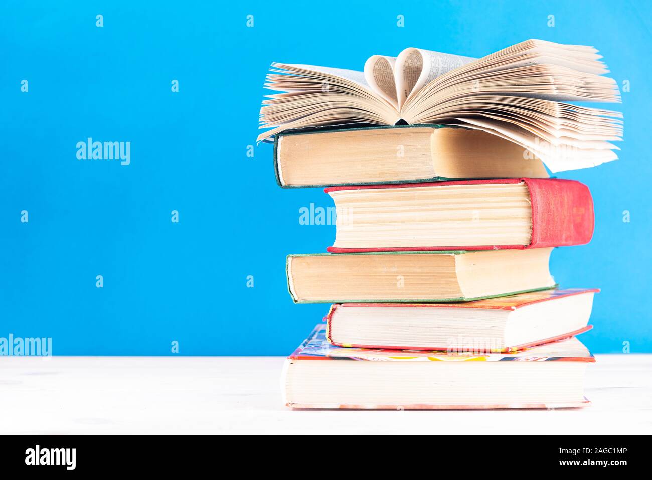 A forma di cuore le pagine del libro su di una pila di vecchi libri hardback con testo dlch spazio. Si torna a scuola. Istruzione Foto Stock