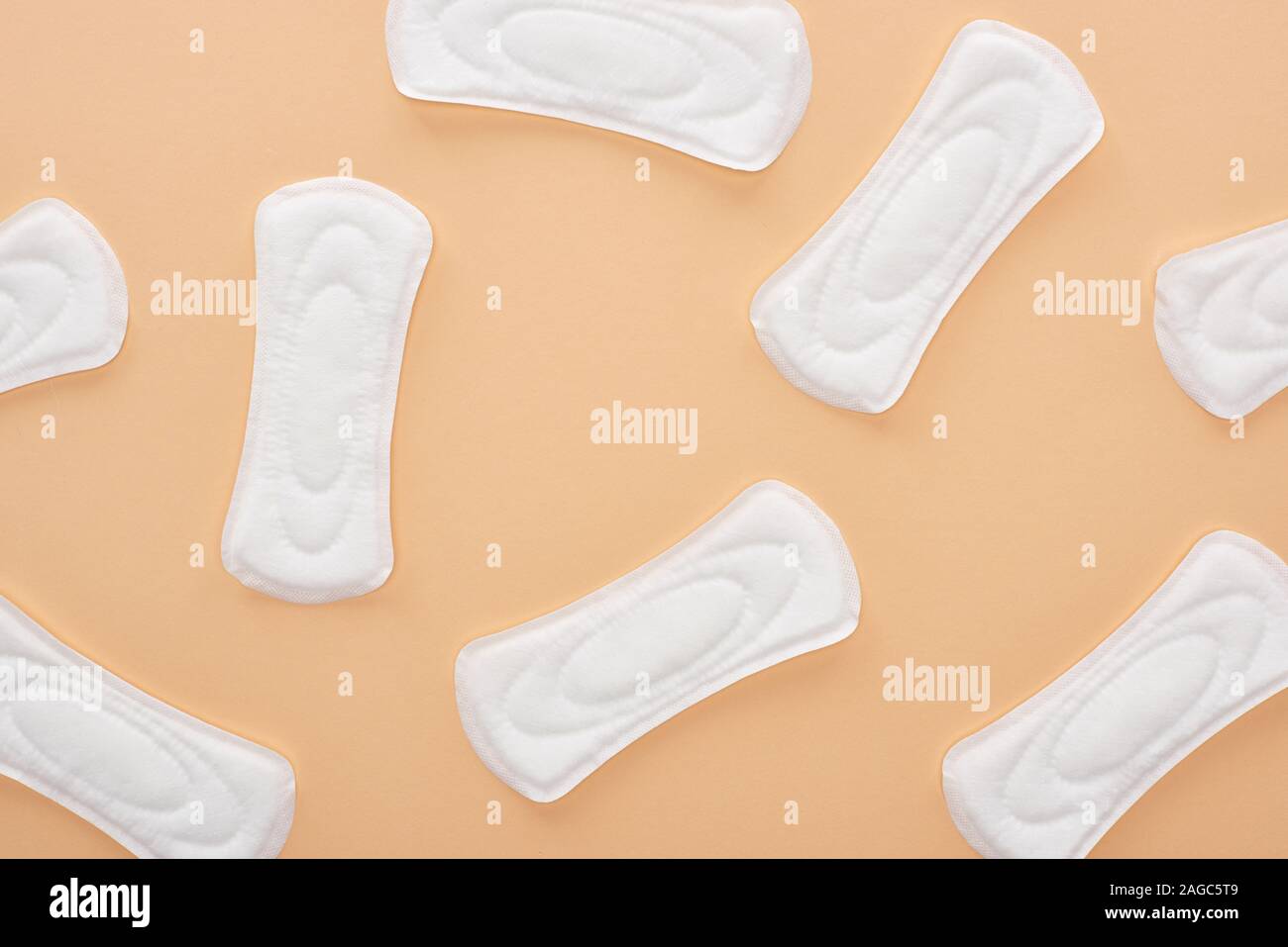 Vista superiore del cotone bianco assorbenti igienici isolati sparsi sul beige Foto Stock